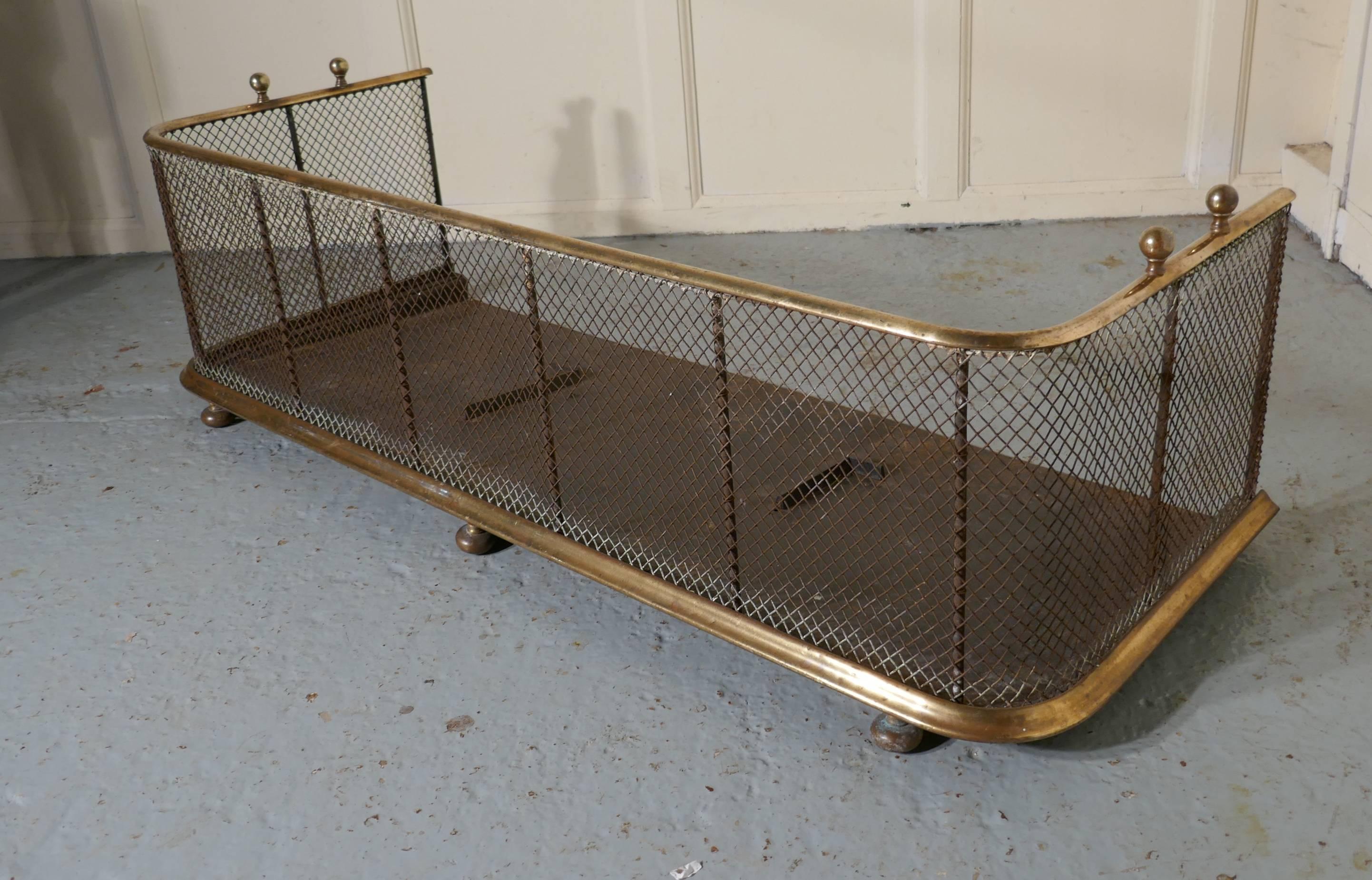 A large Victorian brass and iron fender or fireguard.
 
This is a very heavy quality Victorian antique fire guard, the iron guard has wire mesh and brass rails top and bottom, it has brass knobs on the top and it stands on brass feet, the fender