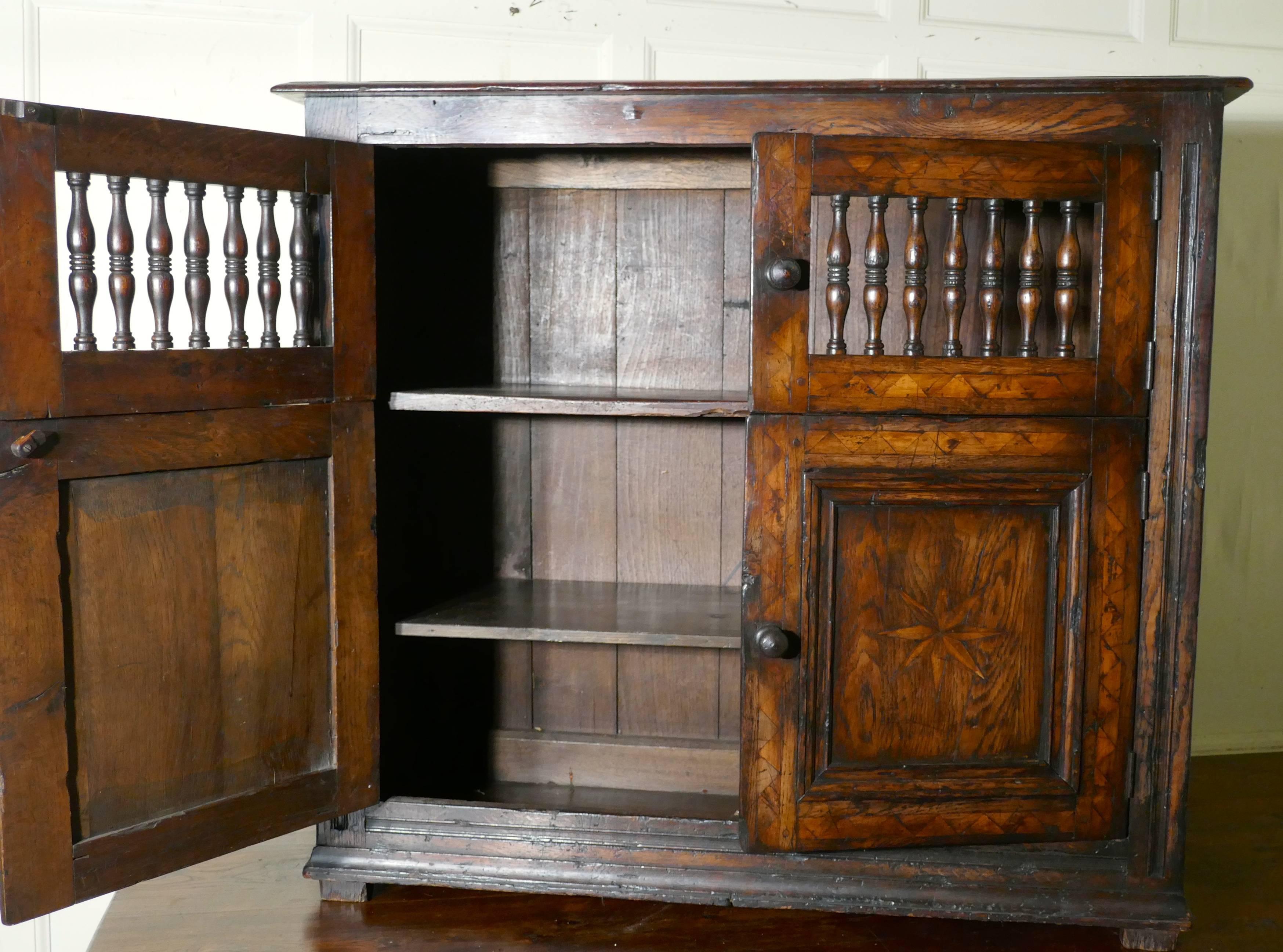 Late 18th century antique inlaid elm food cupboard, bread hutch

This is a lovely and rare country antique livery or food cupboard
The cupboard has four doors, the lower pair enclose shelved cupboard, and the upper pair have turned spindles to