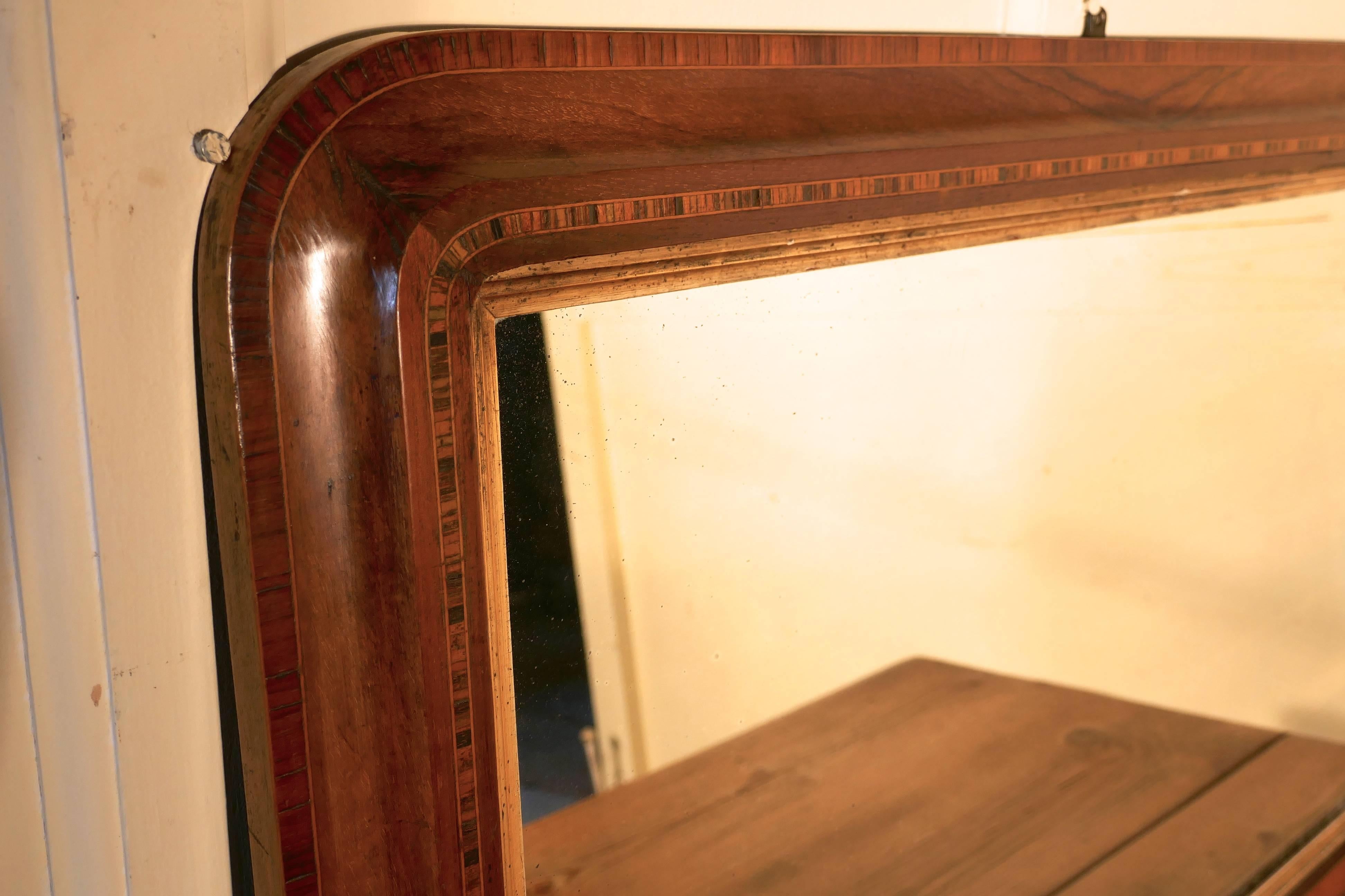 Victorian mirror inlaid walnut overmantle

The mirror frame has rounded top corners, it has a dainty inlaid border at both the outer and inner edge of the frame and it stands on small white ceramic feet
The mirror glass appears to be original and