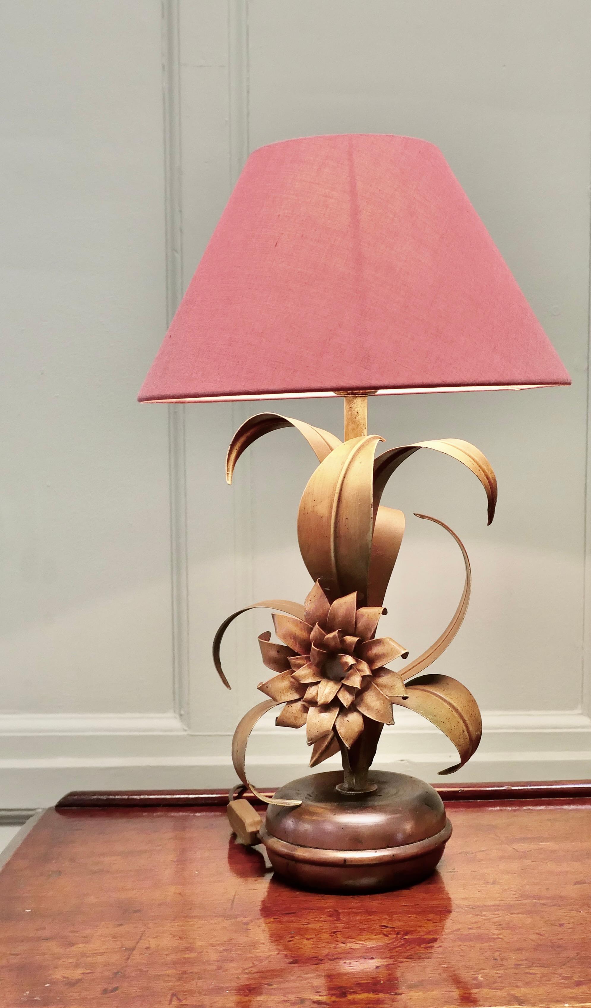 French Painted Toleware Conservatory  Table Lamp

The lamp stands on a round base, and from this grows curling toleware leaves in shades of green and bronze with a large flower at the centre
A super piece with a beautiful design fairly new wiring