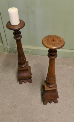 Une paire de grands bougeoirs gothiques en bois tourné et sculpté