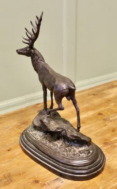 Sculpture en bronze signée représentant un cerf debout sur un rocher, posée sur un socle en marbre