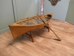Una mesa de centro original con forma de canoa y remos. Una mesa de centro original