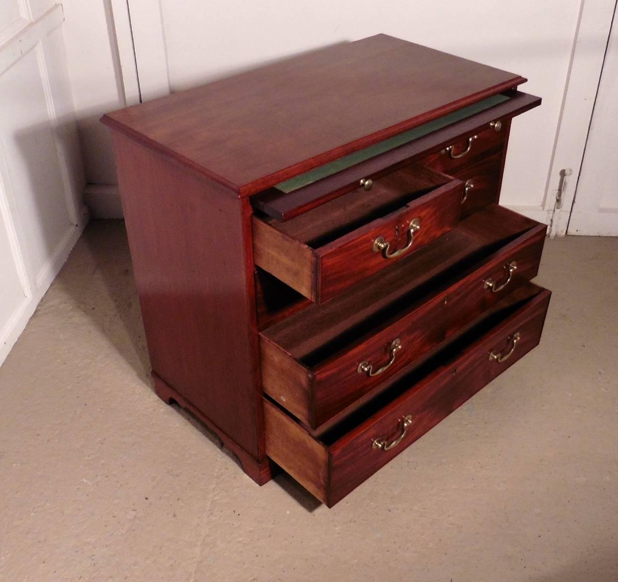 The chest has two short drawers at the top and three graduated long drawers beneath. 
The drawers run very smoothly they have brass swan neck handles, above the drawers we have brushing slide with an inset green base. 
This is a small chest of