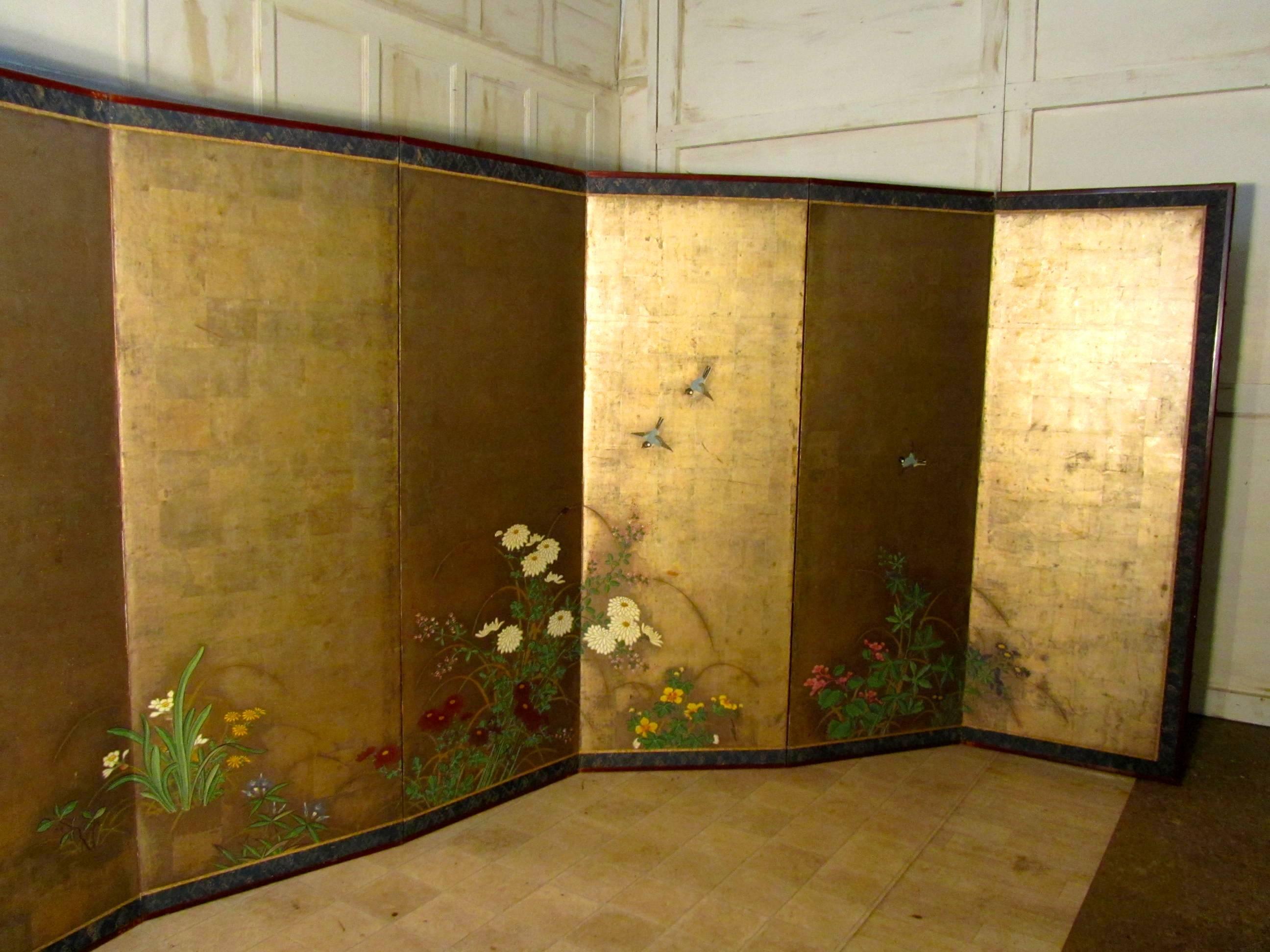 A pair of 18th century gold and painted Japanese six fold screens, (Byobu) Edo period. These are a very rare pair of large Japanese screens, the screens are each six fold and have been provided with clips which join them to make a 12 fold screen The