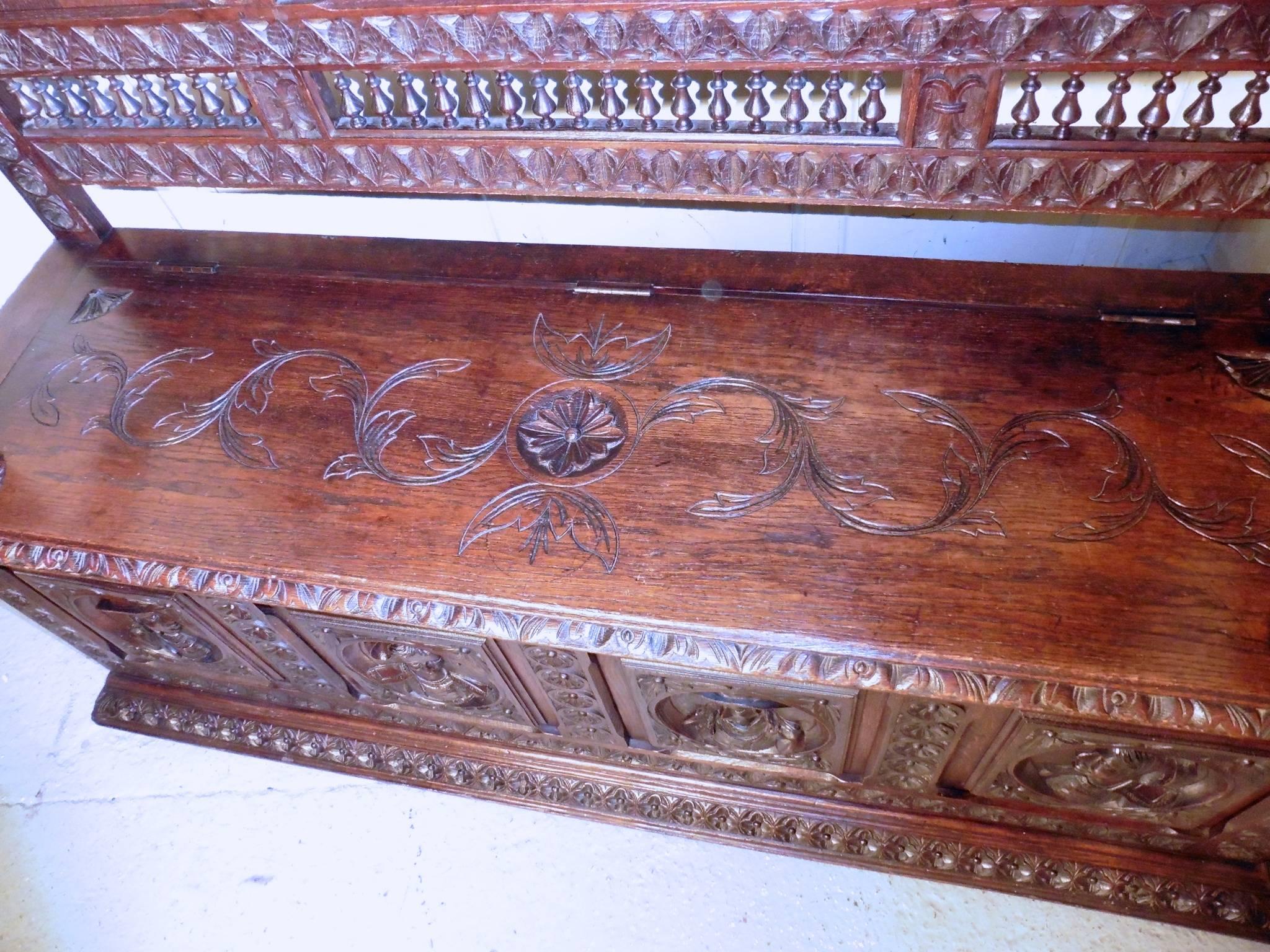 The settle is intricately carved, the back has a very jolly scene in the centre panel, it is set outside a hostelry and shows a young lady seeing off a gentleman who seems to have had rather too much to drink he is sitting back to front on his