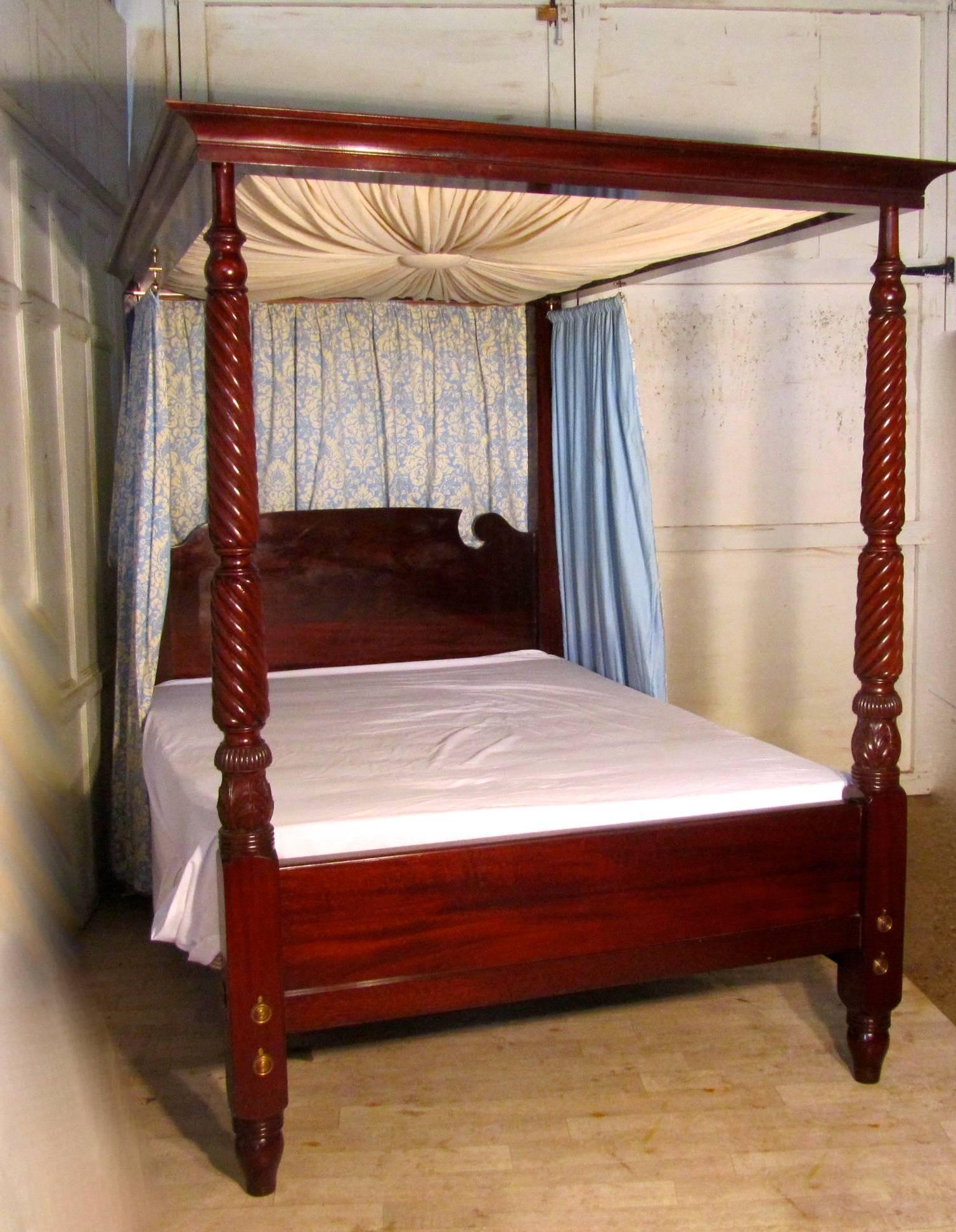 This a wonderful large Victorian mahogany four-poster bed, it has a fabric sun burst canopy, bordered with an outward sweeping cornice. The bed posts are turned mahogany with an elegant twist and carving, the polished mahogany head board has swan