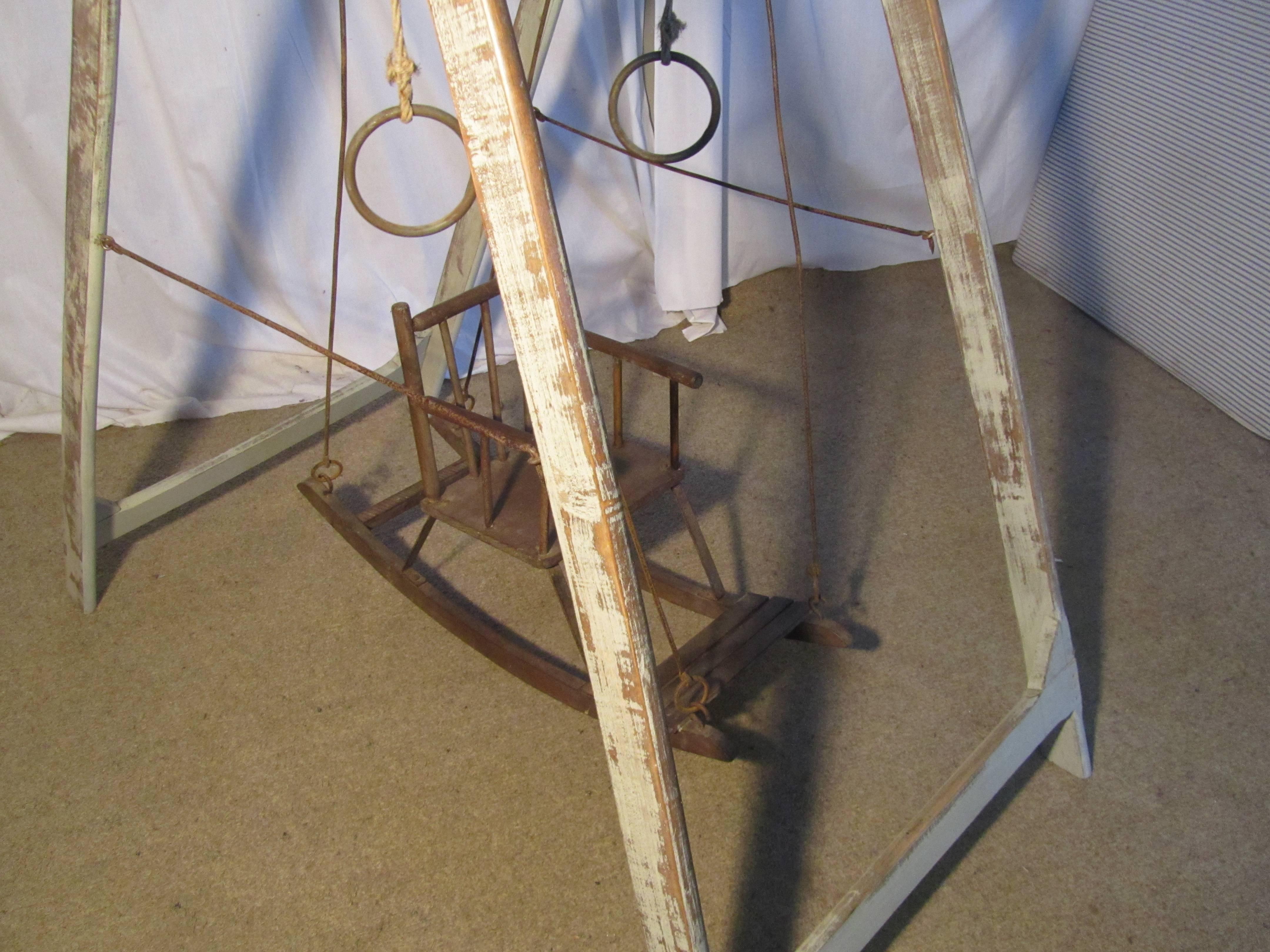 This is a very rare piece, it comes from a Nursery in France, the Wooden frame of the swing folds flat, when opened the swing seat can be hung on the Iron Stays, and the occupier of the seat can push his or herself using the iron rings to swing to