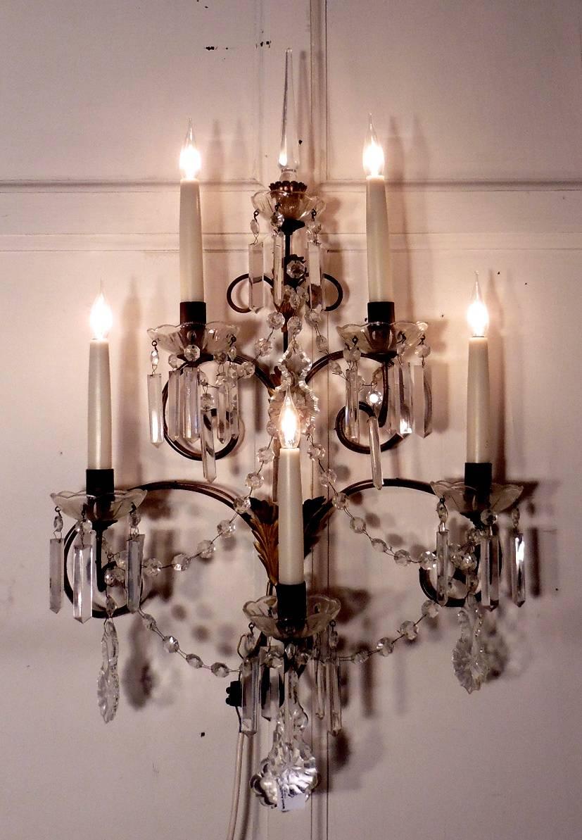 This is a superb pair of very large five sconce wall lights, the lights are made in brass, curled into branches, they are hung with large crystal pendants and chains, and at the very top there is a tall crystal finial. 

All creating a lovely