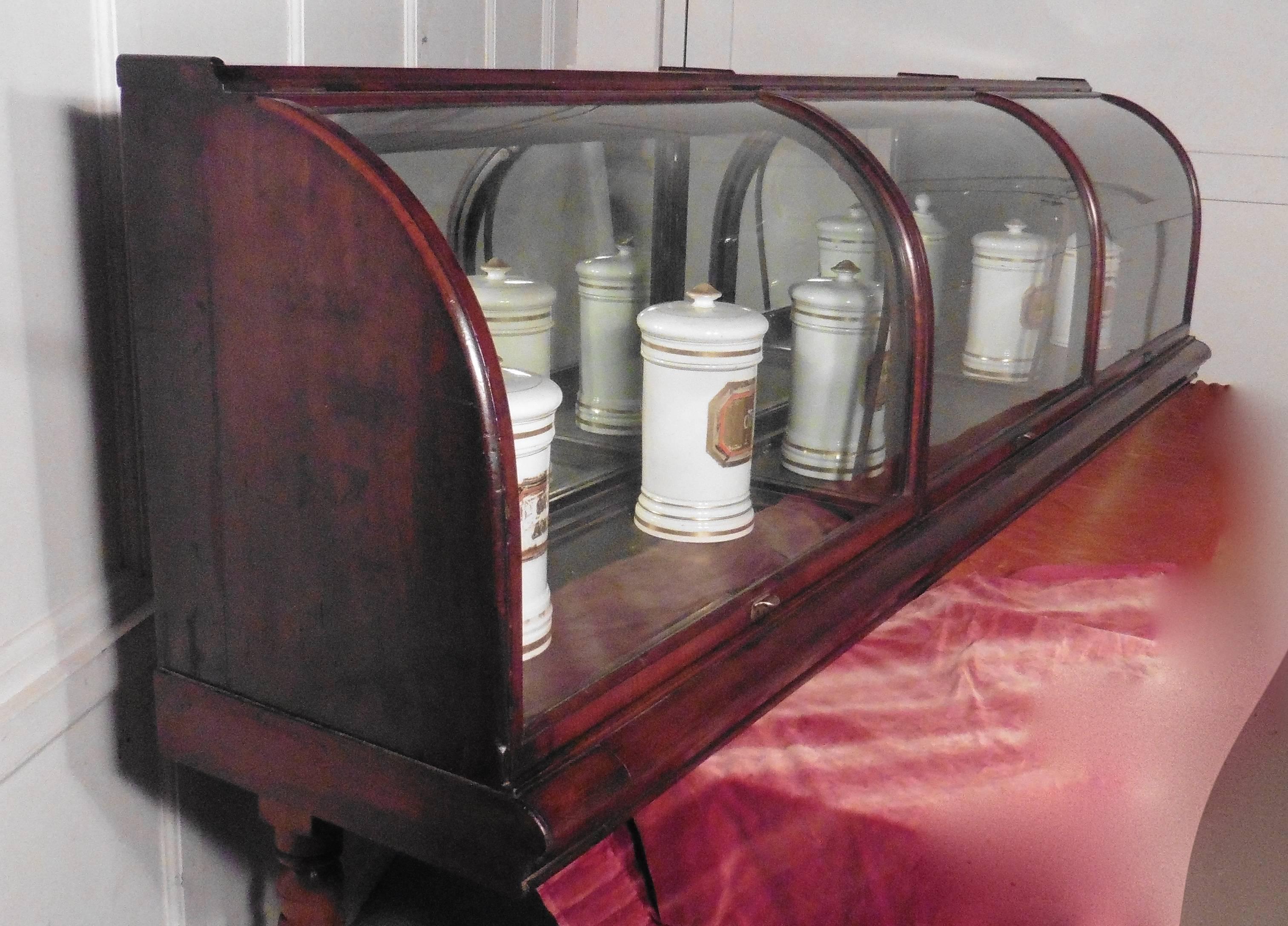 This is a very rare piece with curved glass at the front, the cabinet would have been set against the wall in a 19th century shop.
The Mahogany cabinet is divided into 3 sections by glass panels, it has a curved front surface (D shaped), with