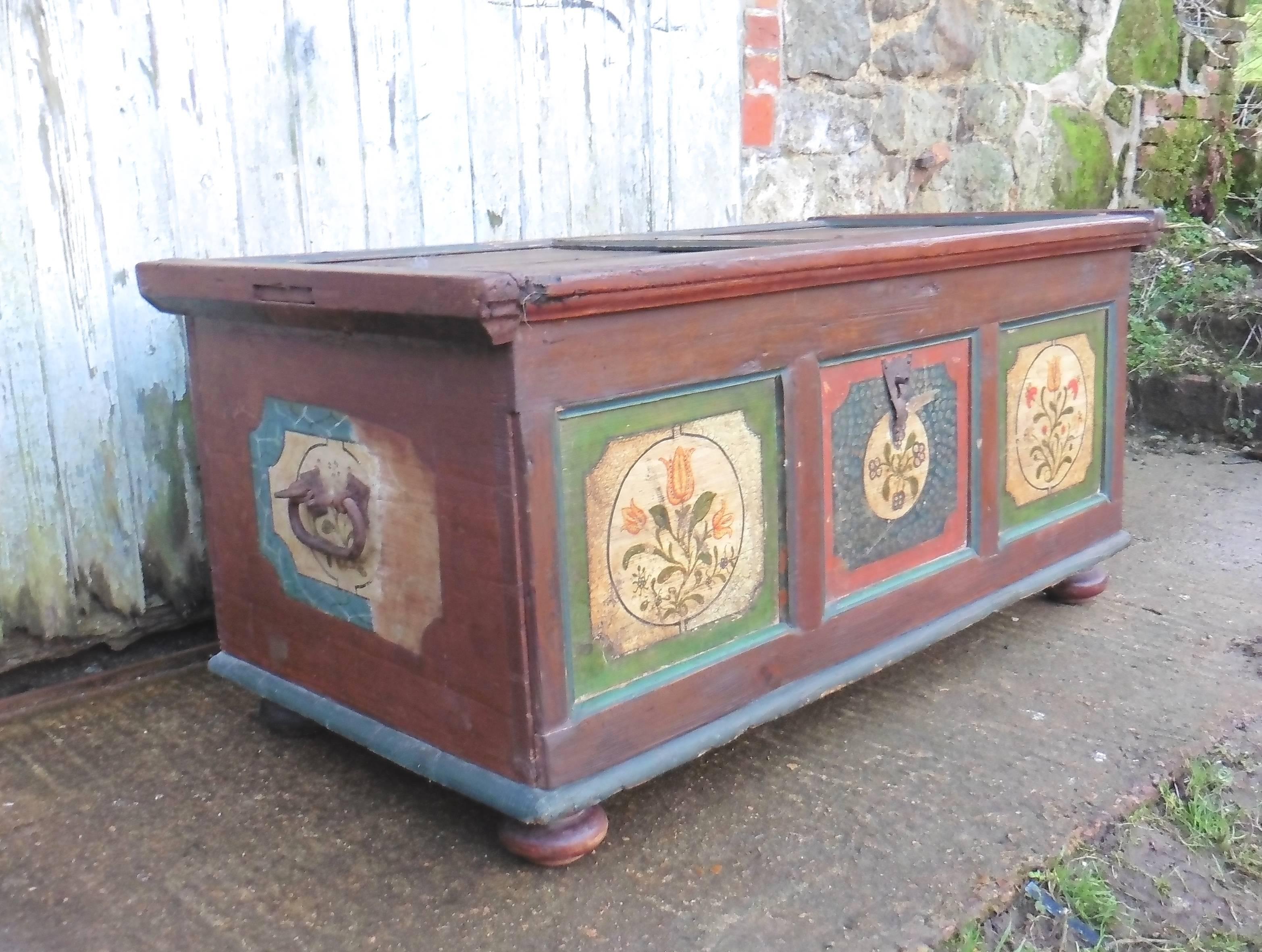 An attractive piece with original hand painting, on the front there are three painted panels and there is one on each side, the top of the chest is also panelled but most of the painted decoration has worn away
The chest stands on bun shaped feet,