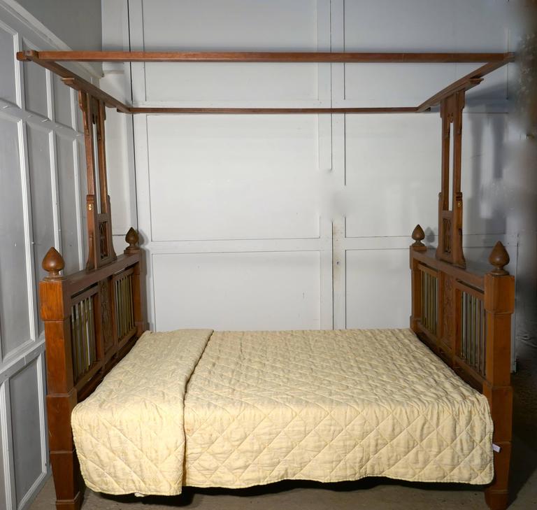 This is a very unusual bed it has slightly square lines with pierced decorated central post leading up from the centre supporting the wide over bed canopy
The bed head and foot have chunky brass rails enclosed in the heavy bed frame and they have