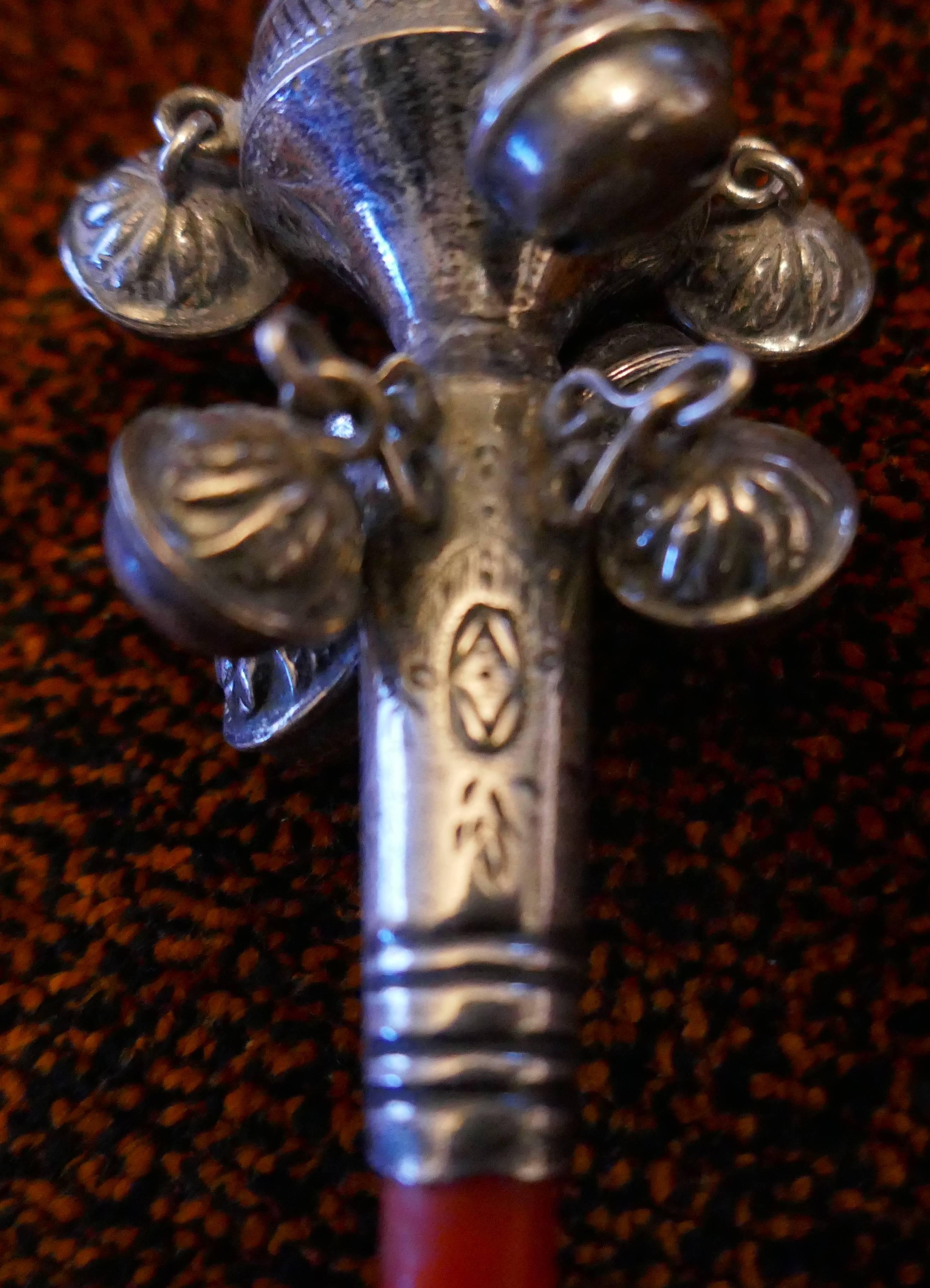 A 19th century silver baby’ rattle with bells, whistle and coral teether.

A charming piece, the rattle originates from Germany, at one end there is a ring to hang it by and a whistle, it has two rows of silver bells, five on one and four on the