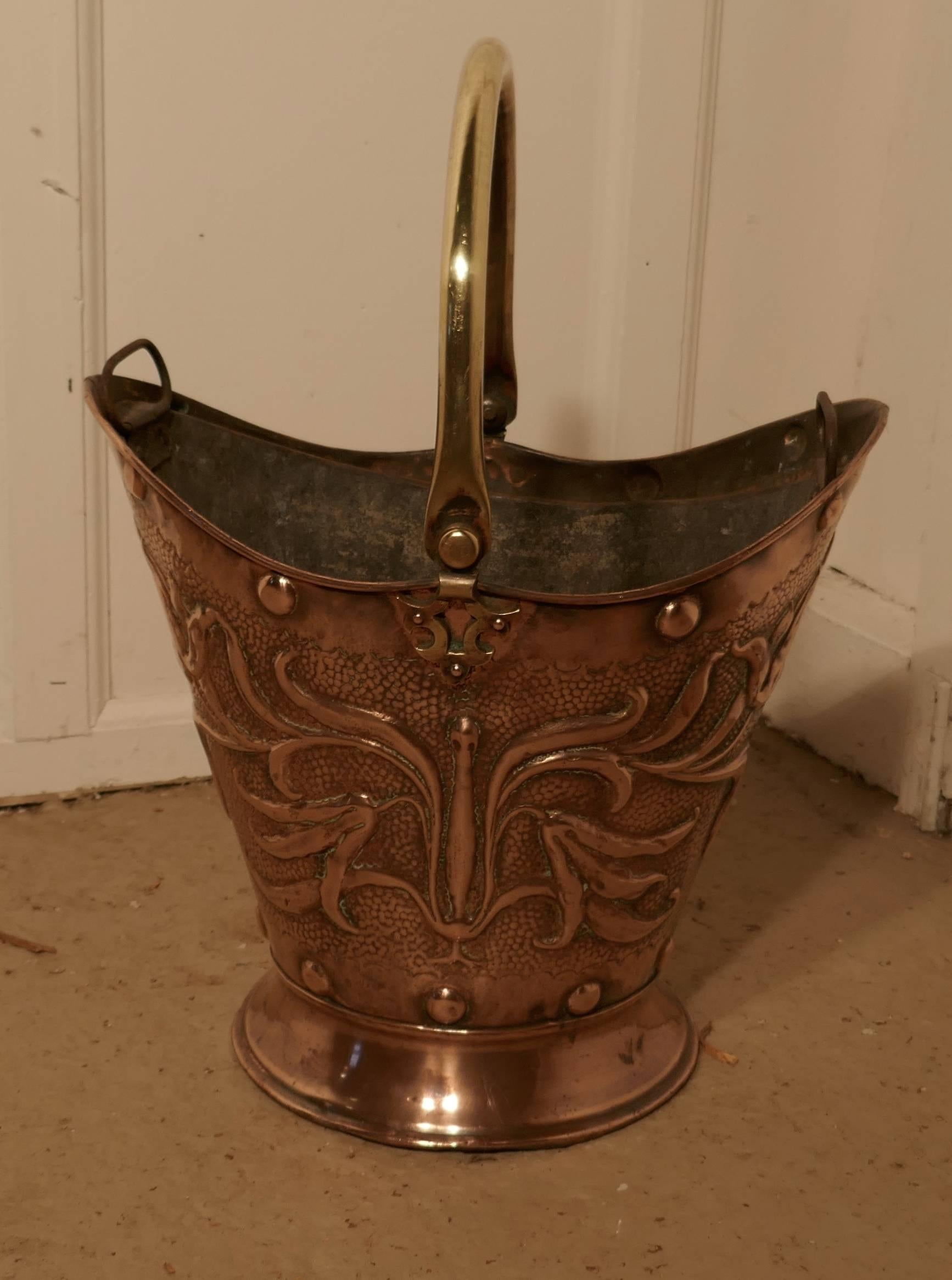 An Art Nouveau embossed copper helmet coal scuttle with liner

This bucket is a very attractive oval shape, it is made in beaten copper with a brass handle, it comes complete with its two handled liner 
The scuttle is in very good used condition,