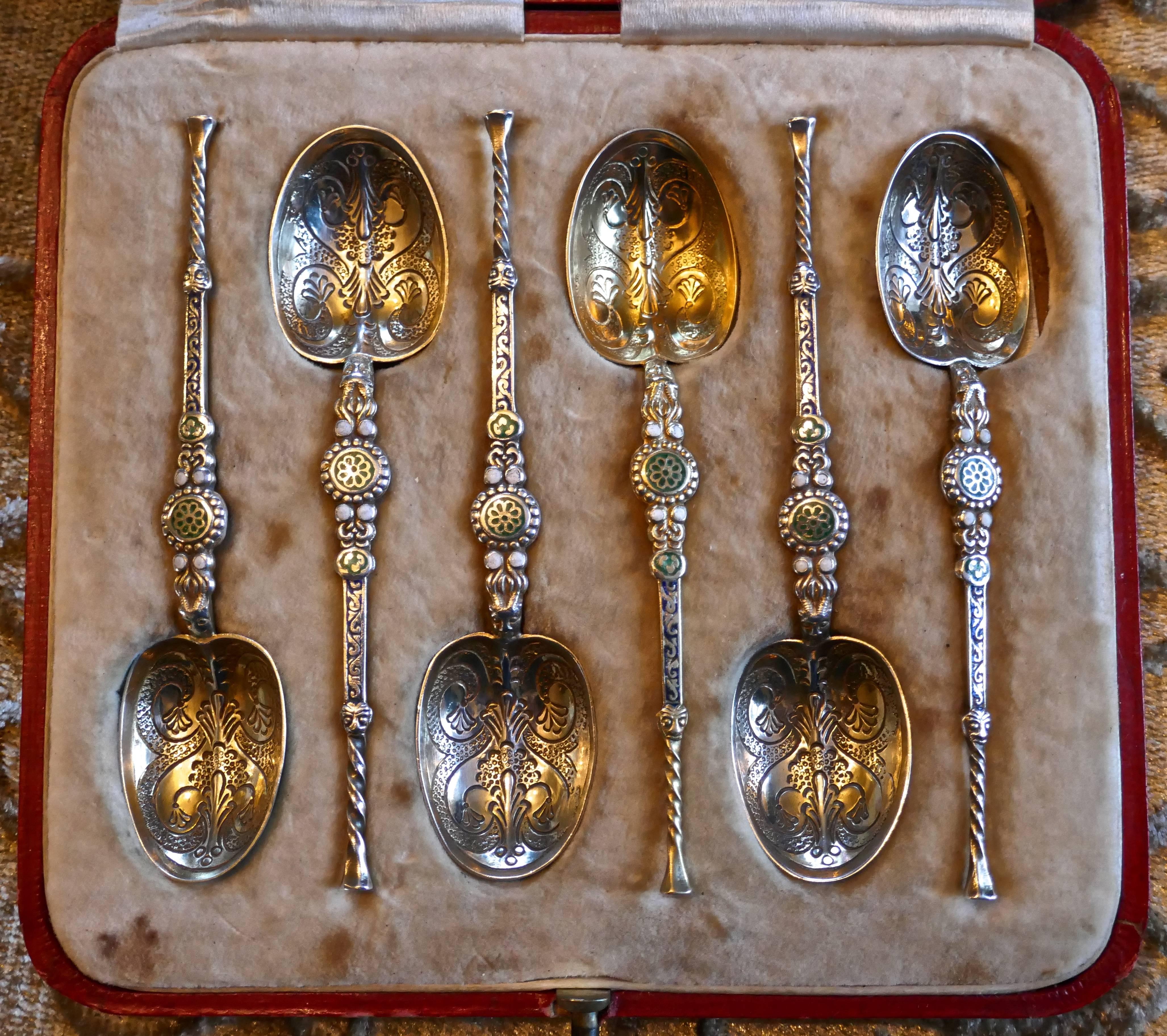This is a very attractive boxed set of silver and enamel anointing spoons. They are in nice condition for their age, with very fine and decorative detail to the bowls and the handles are very delicately twisted and enamelled with blue, green and