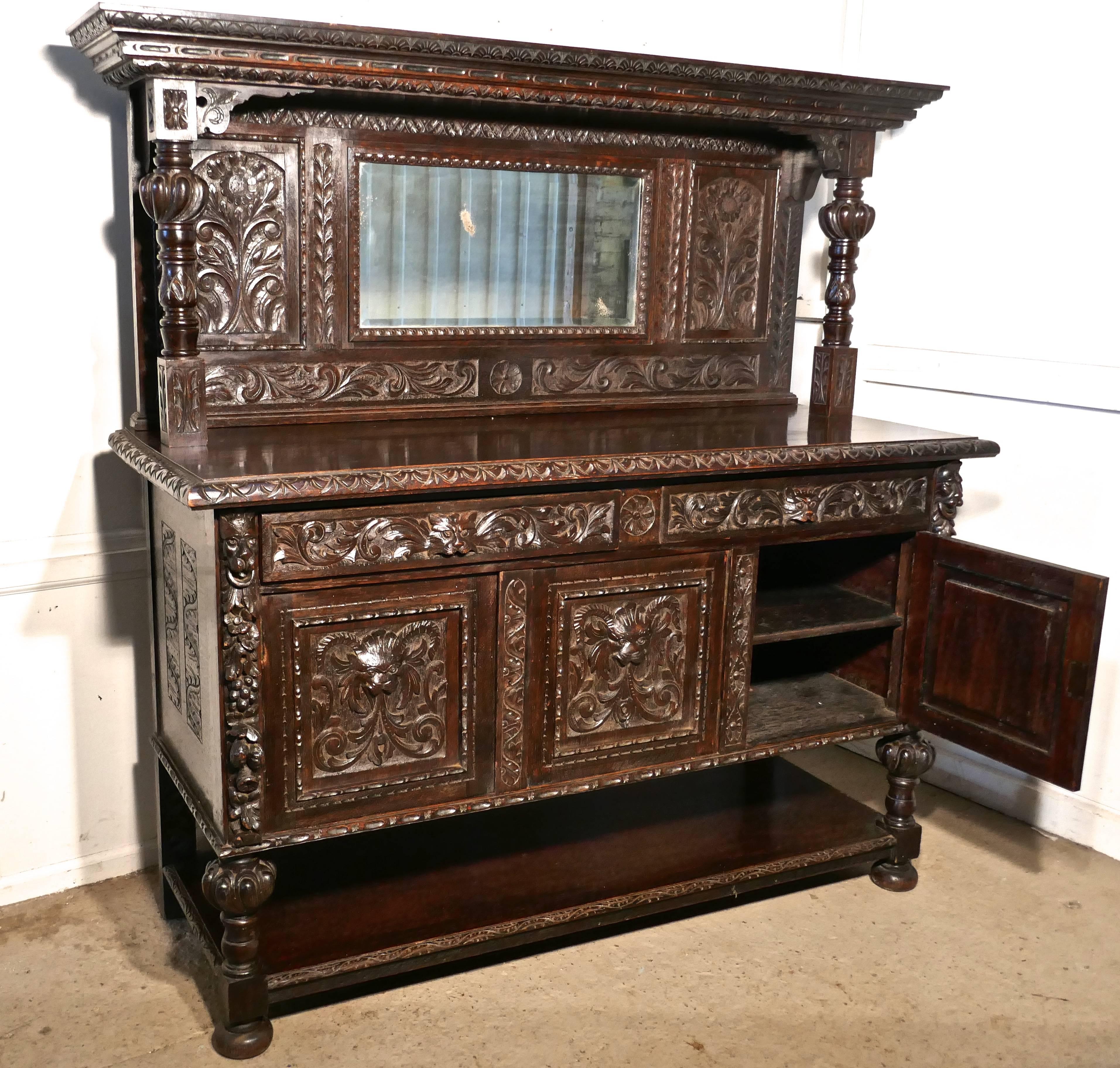 This is a superb and large piece but it is not too high, it has superb quality mythical beasts and green man carvings, on the sides as well as the front

The top section has central mirror bordered by carved panels with turned and carved pillars