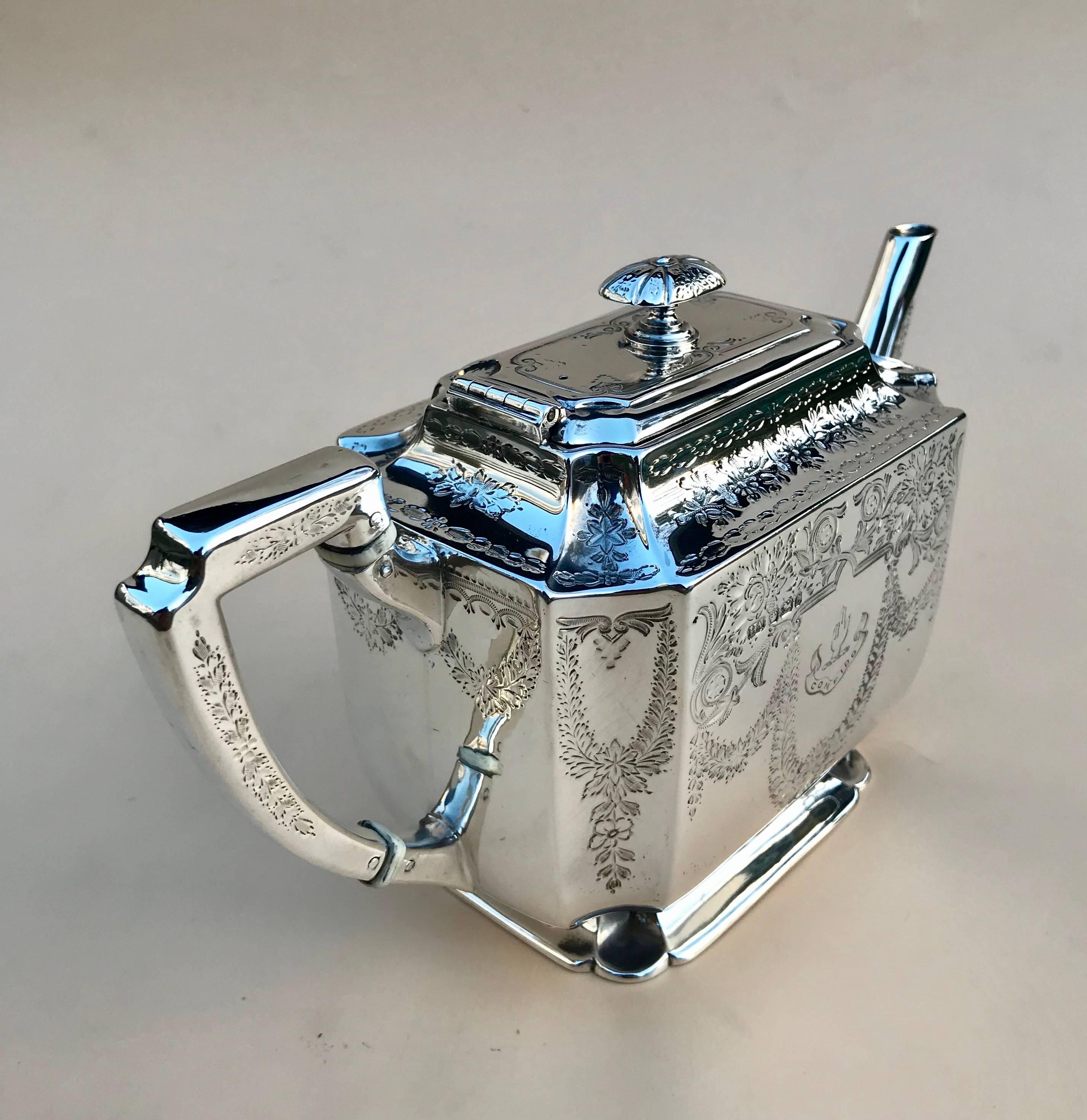 Victorian Silver Batchelor’s Teapot By Atkin Brothers of Sheffield 1895

This is a very attractive piece, the design has rectangular shape and is decorated with flowers and acanthus swags, there is a motto on one side C O N F I D O which translates