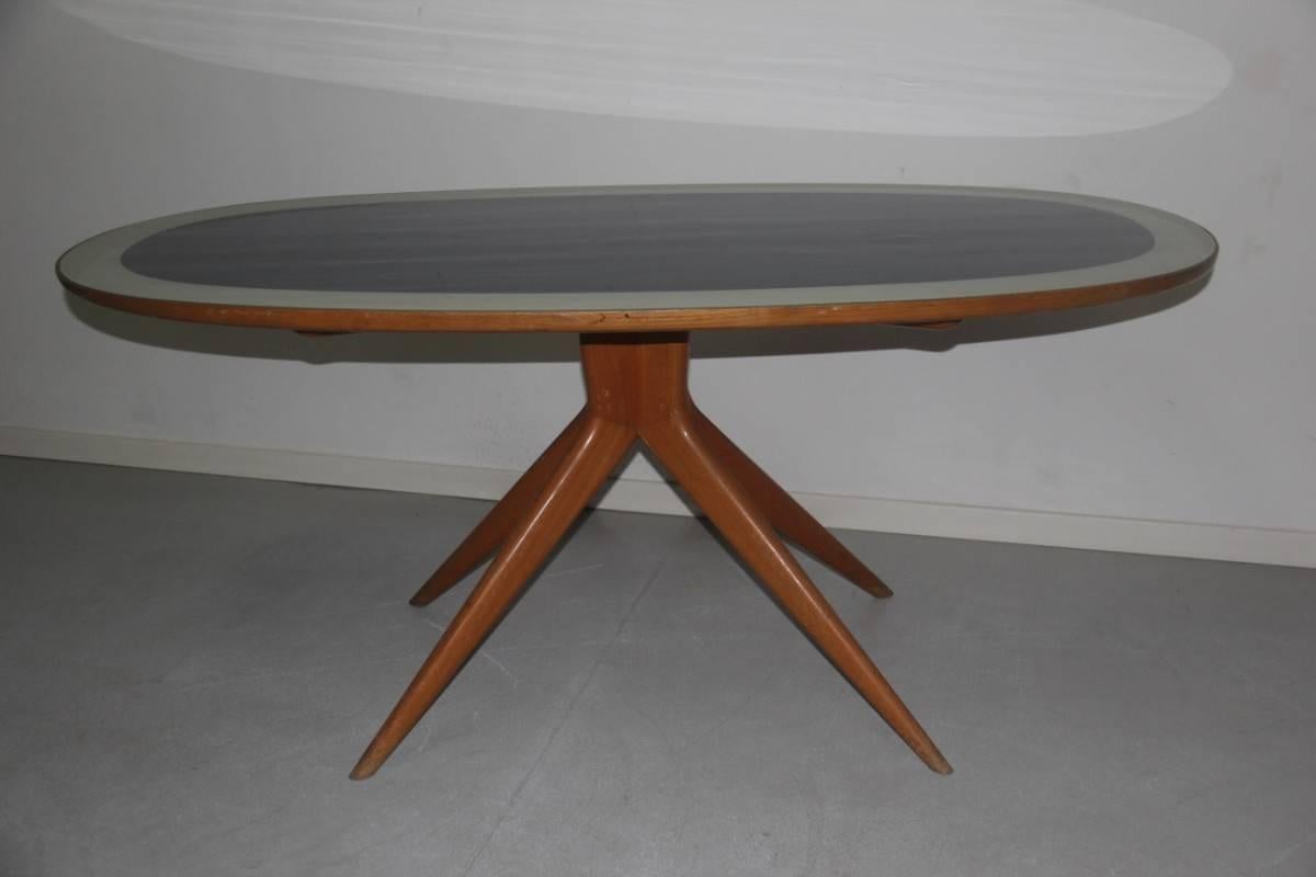 Particular dining room table Dassi design Italian Mid-Century, 1950s, made of chestnut wood and colored cobalt blue and light gray on the side edges, even the oval shape makes it very special.