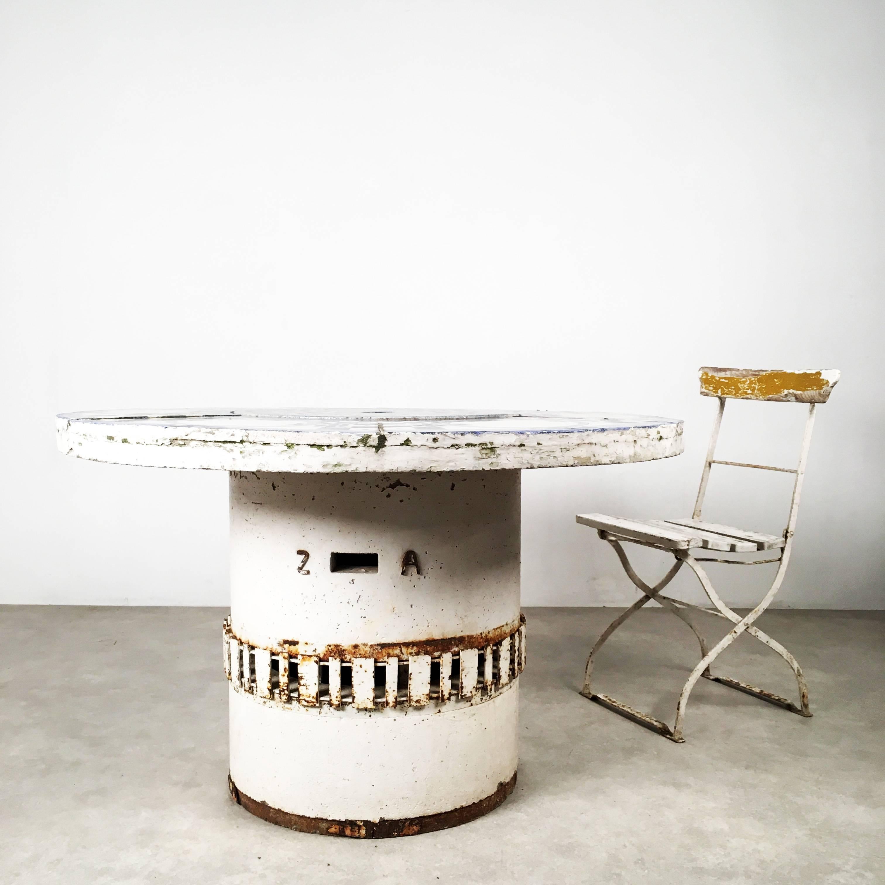 Phantastic barbecue table, made in the 1950s, most probably in Germany. The table is made for outdoor use and contains a barbecue in the middle. If not in use, the barbecue can be covered with a tile disc.

The base of the table consists of two