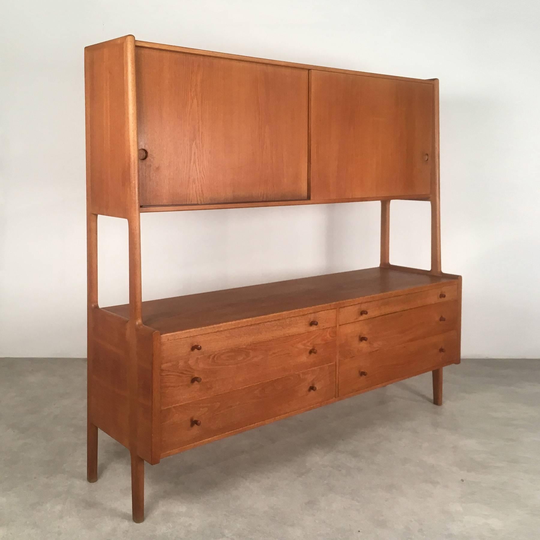 Fantastic highboard, designed in 1953 by Hans J. Wegner, manufactured in 1963 by Ry Møbler Denmark. The piece stands out for its extremely high quality craftsmanship and well thought out details. Its airy elegance and slightly organic design make