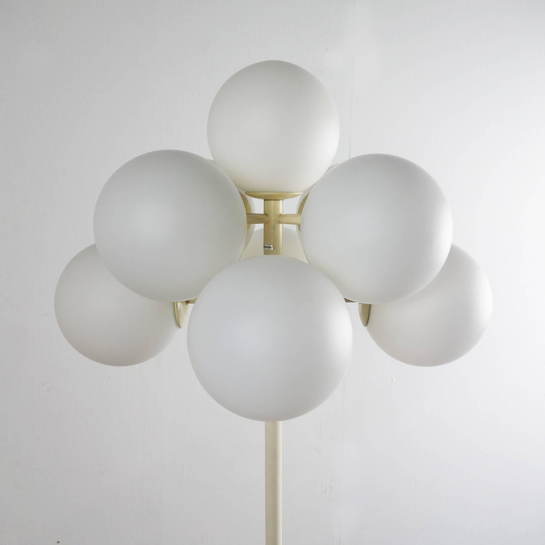 Floor lamp from the 1960s, manufactured in Switzerland by Temde Leuchten. The lamp stands out for its stunning Space Age design. It is equipped with nine mat white glass globes, each covering one E14 light bulb.
 