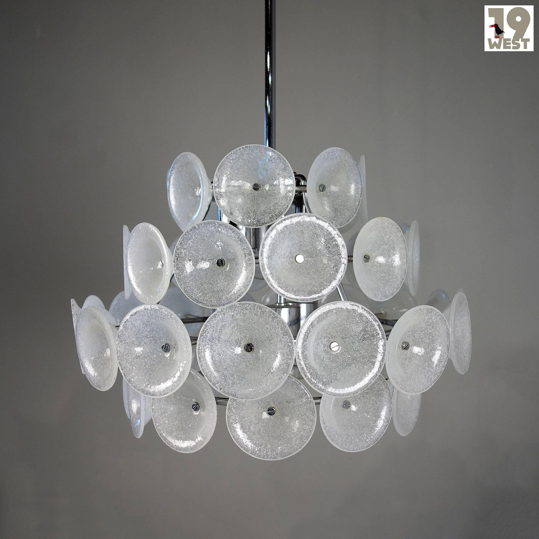 Beautiful ceiling chandelier from the 1960s. The structure of the slightly funnel-shaped glass elements and the quality of the luminaire's workmanship suggest that it was made by Kalmar.
 
The candlestick consists of a chrome-plated steel frame