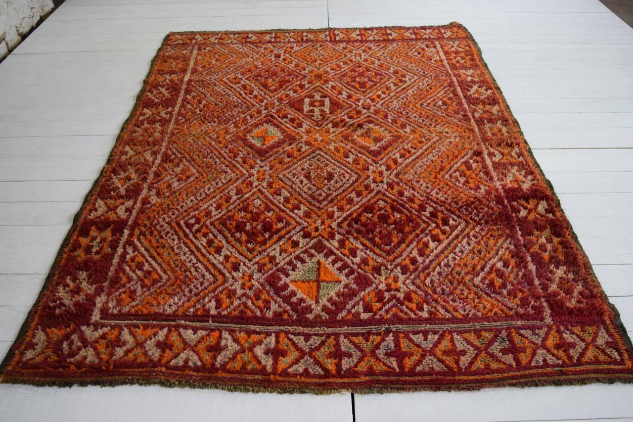 With a vibrant palette of reds, oranges and ivory, this Moroccan carpet has wonderful positive energy. In addition, the very soft wool and long pile feels great underfoot. In good condition, the rug has just been expertly hand-cleaned and conserved.
