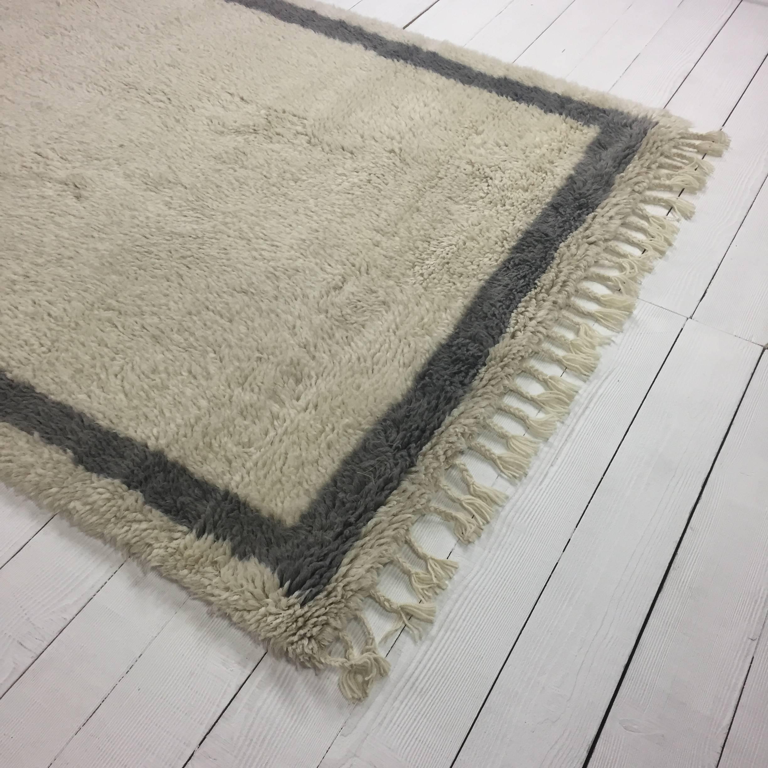 Luxurious handmade shaggy wool rug in ivory wool with graphite grey border. Inspired by Beni Ourain rugs from Morocco but with a more contemporary and less tribal design. Unbelievably soft and fluffy underfoot, perfect for bare feet.

Available in