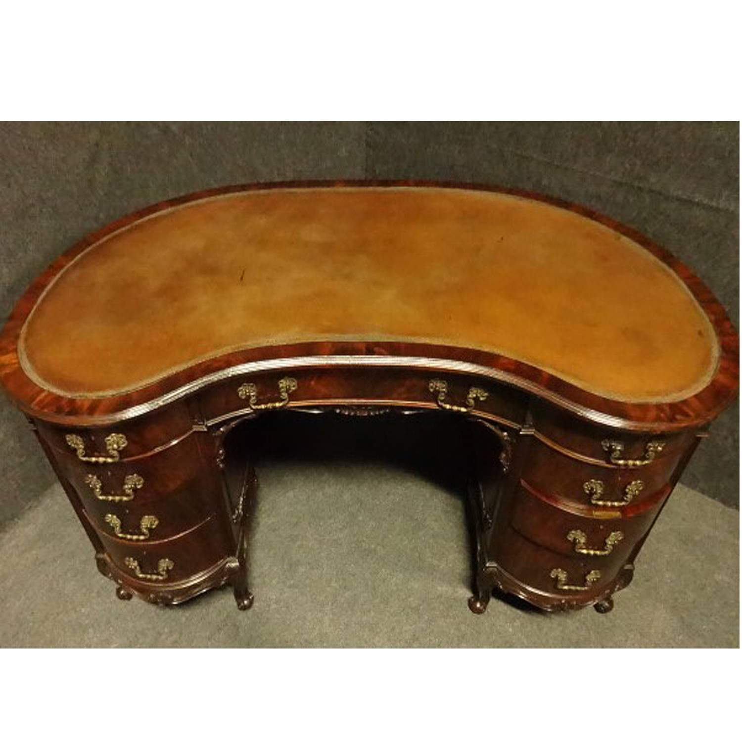A top quality English mahogany kidney shaped kneehole desk in the Chippendale style, all solid mahogany including drawer linings, top quality locks and handles with the key, original hide skiver, excellent colour and in excellent original condition.