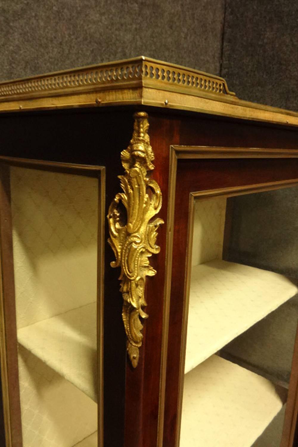 Excellent quality mahogany display vitreen with brass inlaid door panel and brass mouldings to sides and front, gilt metal mounts and brass gallery with a rouge marble top, relined in cream and in excellent original condition.