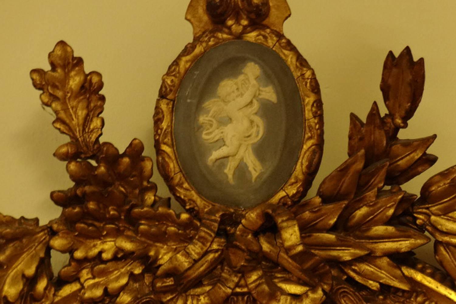 A stunning early Regency gilt oval mirror, with three candle sconces, this mirror has a ceramic plaque to the top, and overall is in excellent condition, slight misting to the plate.

Measures: 59" high
21.5" wide
11" depth.

 