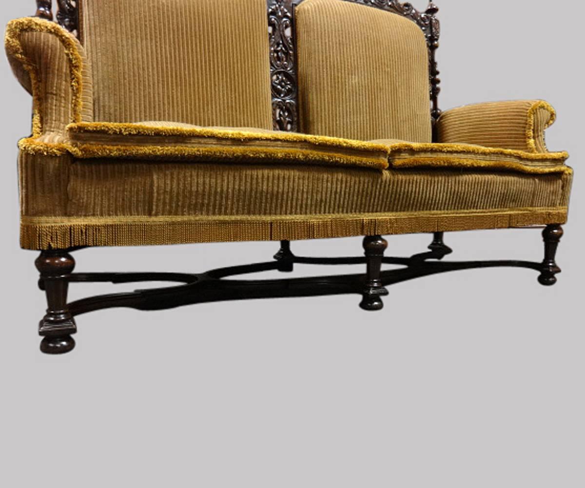A superb carved walnut two-seat sofa, settee, standing on six legs with serpentine under tier, dark gold plush upholstery with feather filled cushions, lovely color and in excellent original condition.