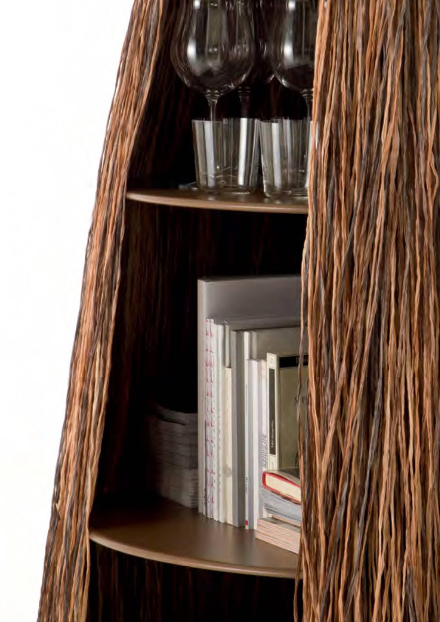 Mysterious container with central support structure and five decreasing circular shelves, completely covered by long synthetic raffia with special fireproof treatment. A container with a mysterious volume and multiple openings.