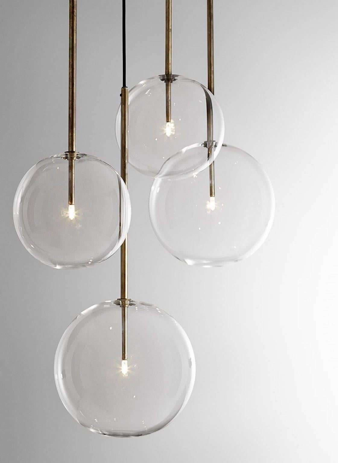 Hanging lamp with halogen point light (20 Watt). Transparent blown glass sphere. Metal parts in hand burnished brass. The hand burnished brass finish looks naturally spotted and irregular. 

Due to this craft made processing, each product is unique