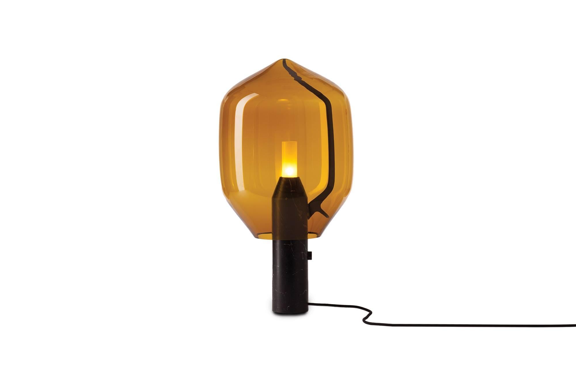 The Lighthouse table lamp comes with a honed black Marquina marble or Carrara marble base and the shade in amber or grey glass. 

An elegant equation of modern and traditional craftsmanship, the Lighthouse balances a Venetian mouth blown glass