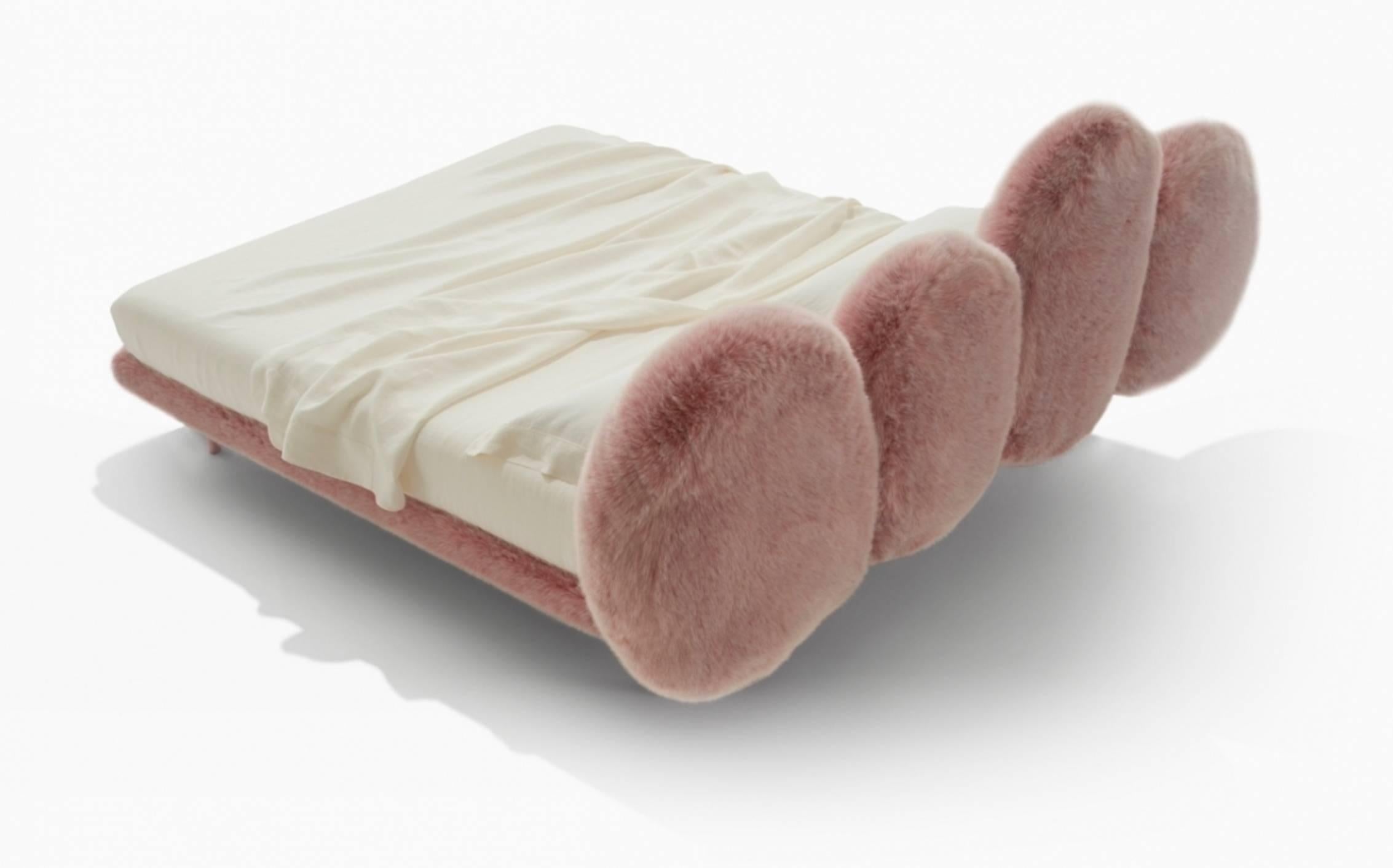 Upholstered bed made up of four pillows attached to a painted metal tube frame. Padded with polyurethane foam and synthetic wadding. Soft to the touch like a caress, thanks to the faux fur lining.

Possible in pink, black or white faux fur. Also