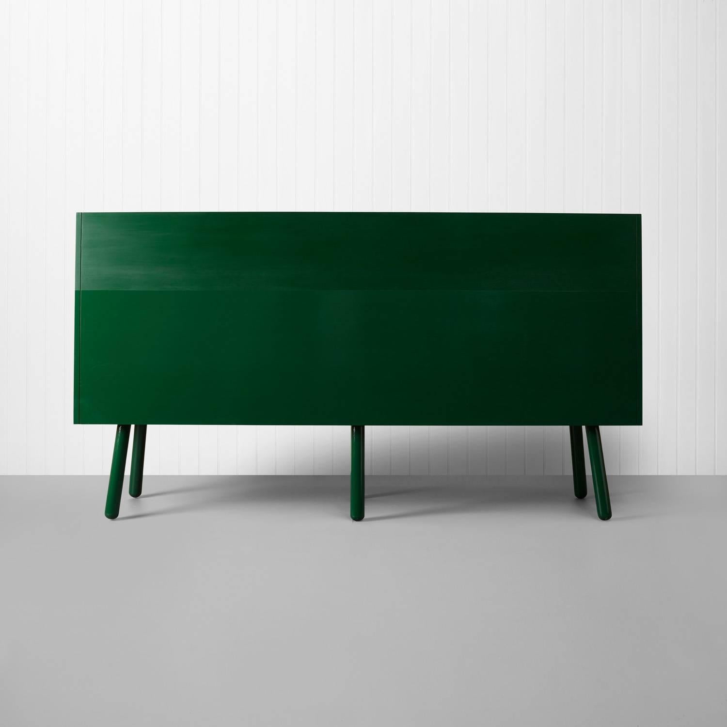 The green plank settle bench is a modern interpretation of the old- English settle, with a deep seat and a high back giving an inviting sense of enclosure. The settle is 2.4 metres long and constructed from solid British Douglas FIr timber, painted