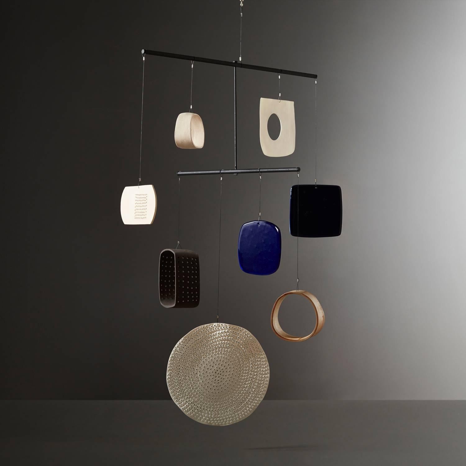 Daniel Reynolds' navy and apothecary blue mobile is a large handmade mobile, composed of a gourd section, porcelain, stoneware, and glass shapes in varying hues. Adhering to a simple colour palette of black, white, blue and cream Daniel Reynold’s