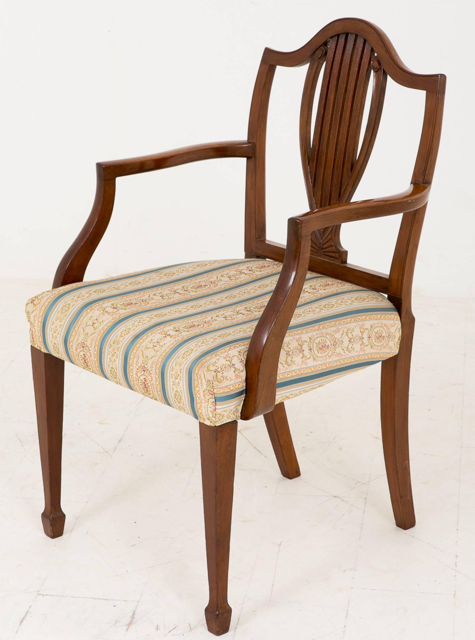 Set of eight (six + two) mahogany Hepplewhite influenced chairs.
Standing on tapered legs with a spade foot.
Featuring a carved and fluted lyre shaped back splat.

Size:
Single (no arms) 
width 20" (51cm)
height 37" (94cm)
seat