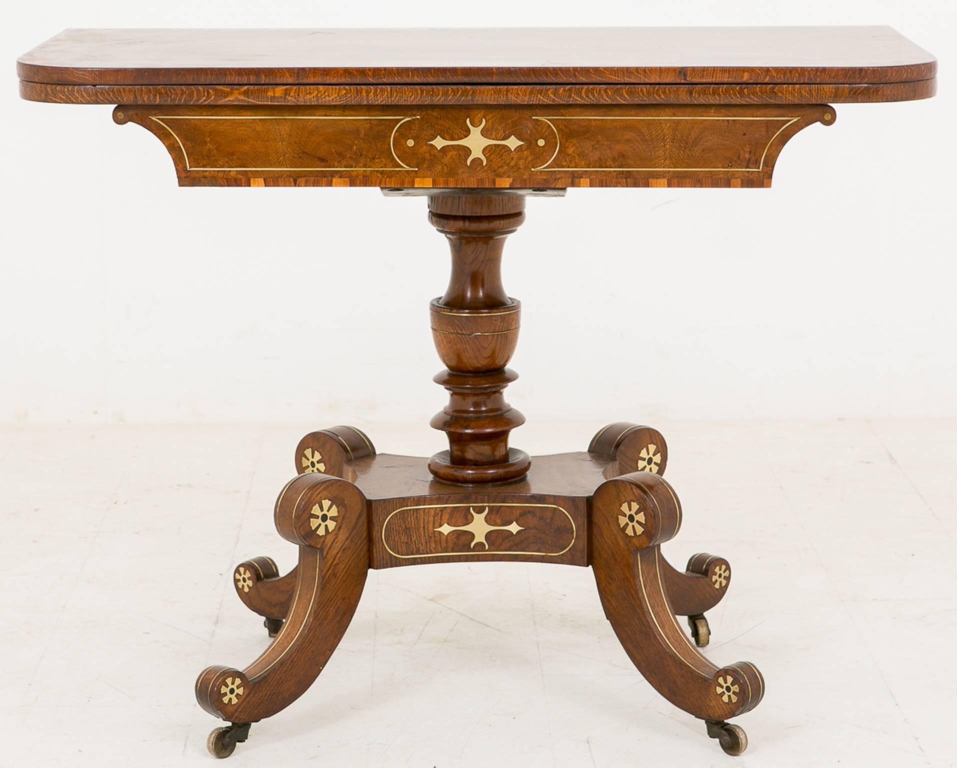 Stunning Regency hand cut brass inlaid pollard oak tea table.
Standing on brass castors with swept legs and urn shaped turned column. Featuring a fold over swivel top with rosewood crossbanding.

Size open:
36