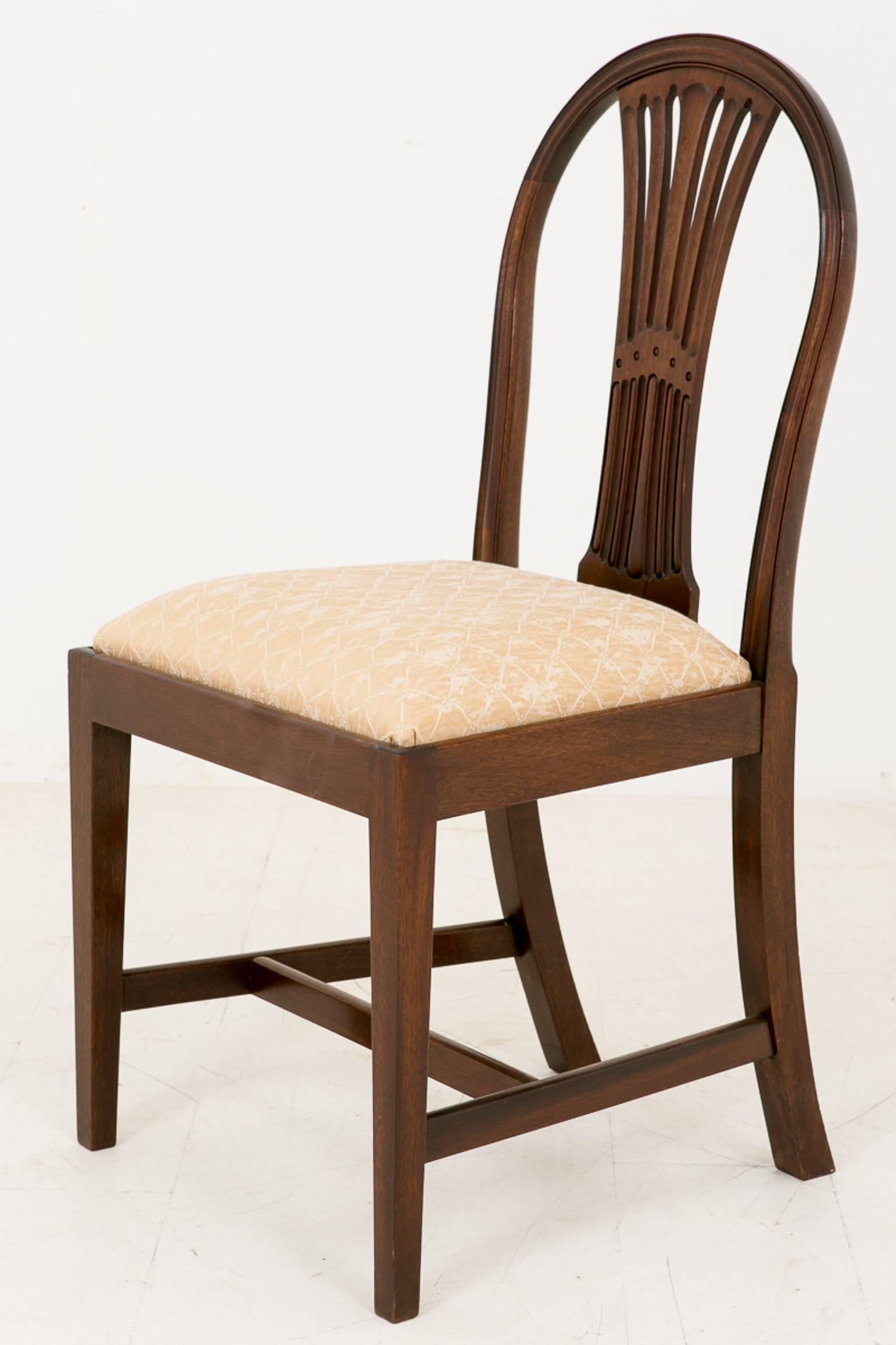 Set of ten mahogany Hepplewhite influenced dining chairs. Standing on square tapered legs. Each chair having a pierced and carved back splat.
These chairs have recently been refurbished and are in excellent condition.

Size:
Seat width 19