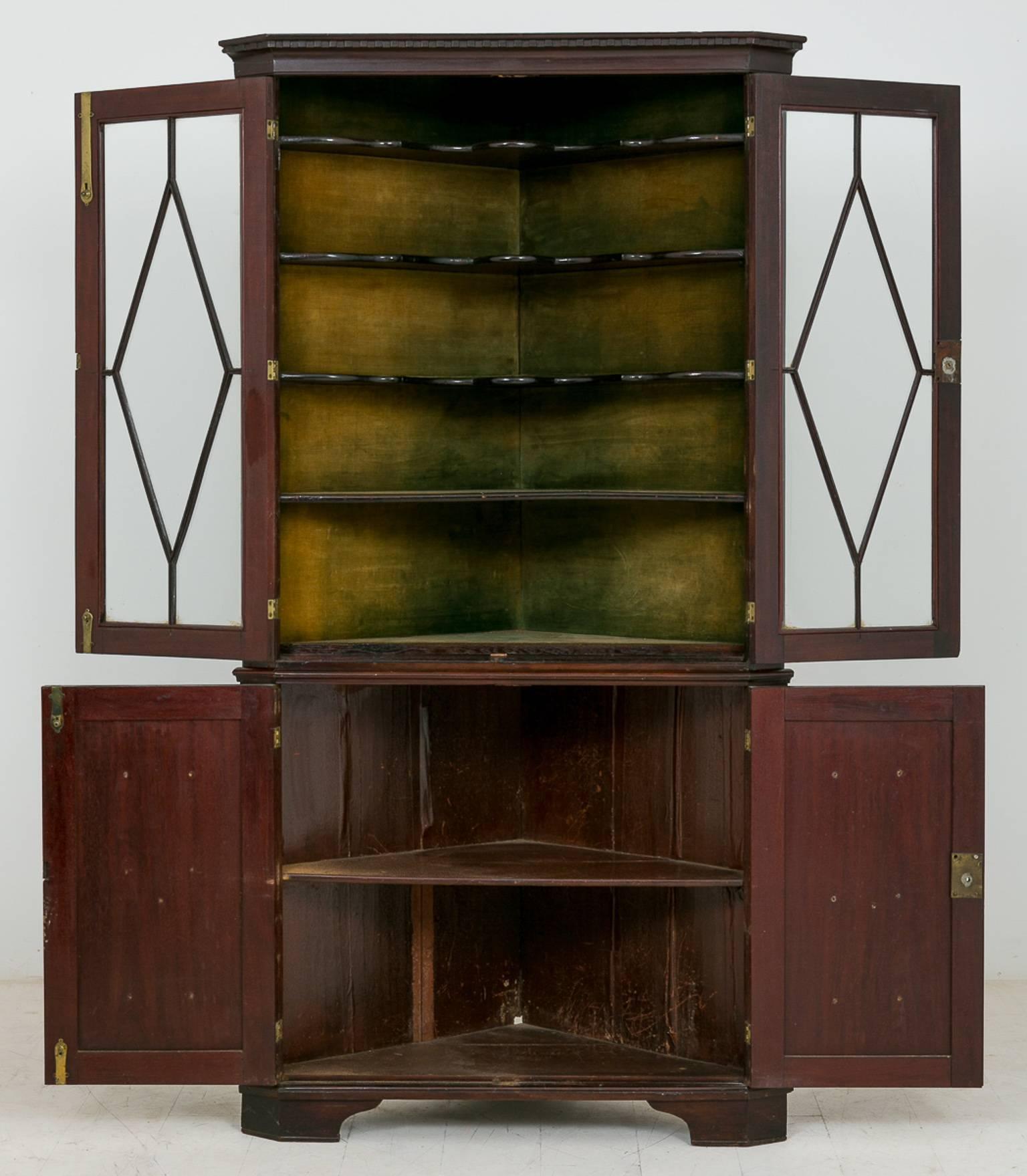 George II mahogany glazed corner cabinet.
Standing on bracket feet, featuring two fielded panel doors on the bottom section, the top section having a pair of astragal glazed doors revealing wonderful shaped shelves (typically early
