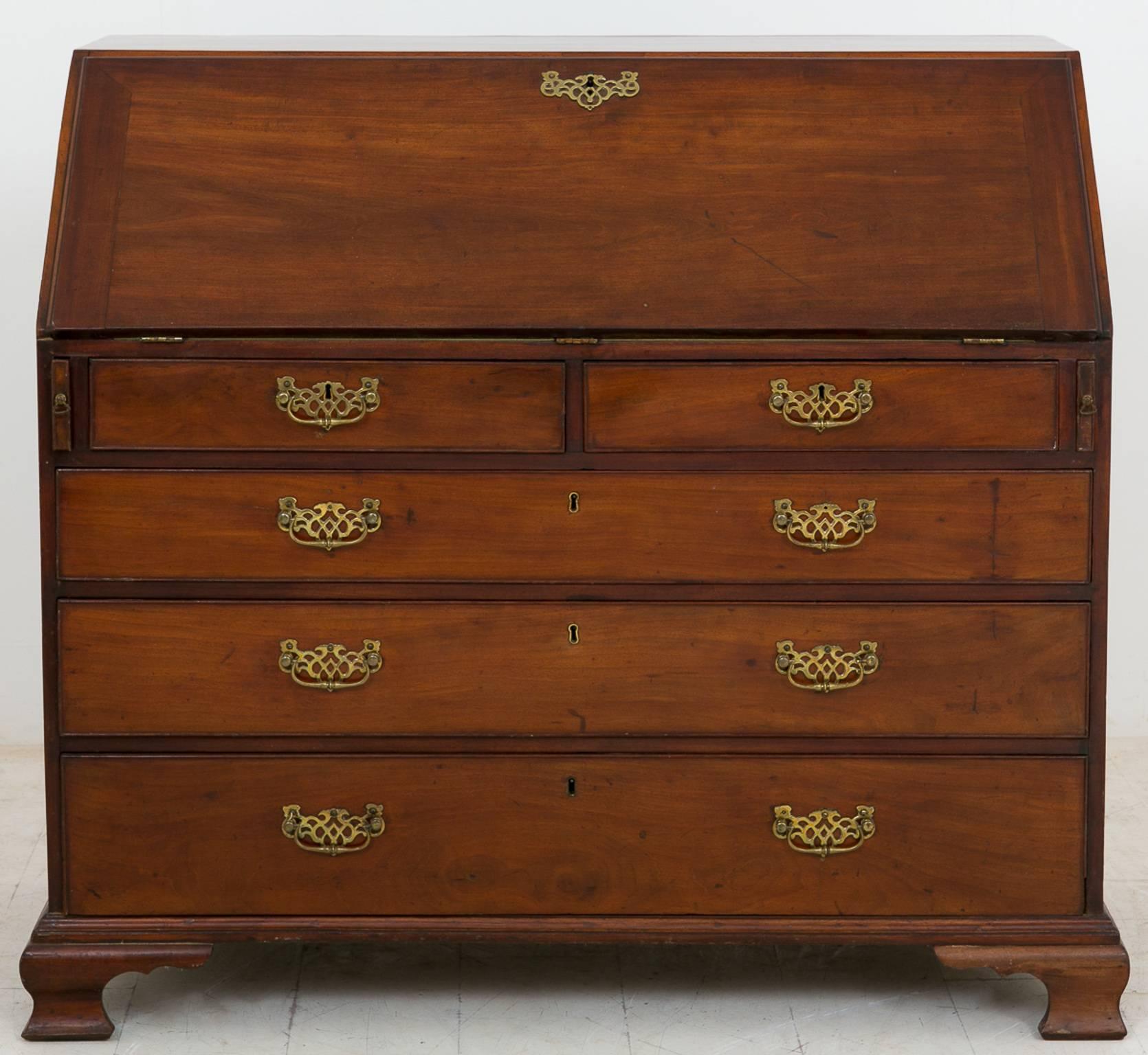 Georgian Mahogany Bureau. Standing on Ogee feet.
Two over three oak lined graduated drawers with original handles.
The interior consisting of an arrangement of pigeonholes and drawers the central cupboard featuring a marquetry panel.
The green