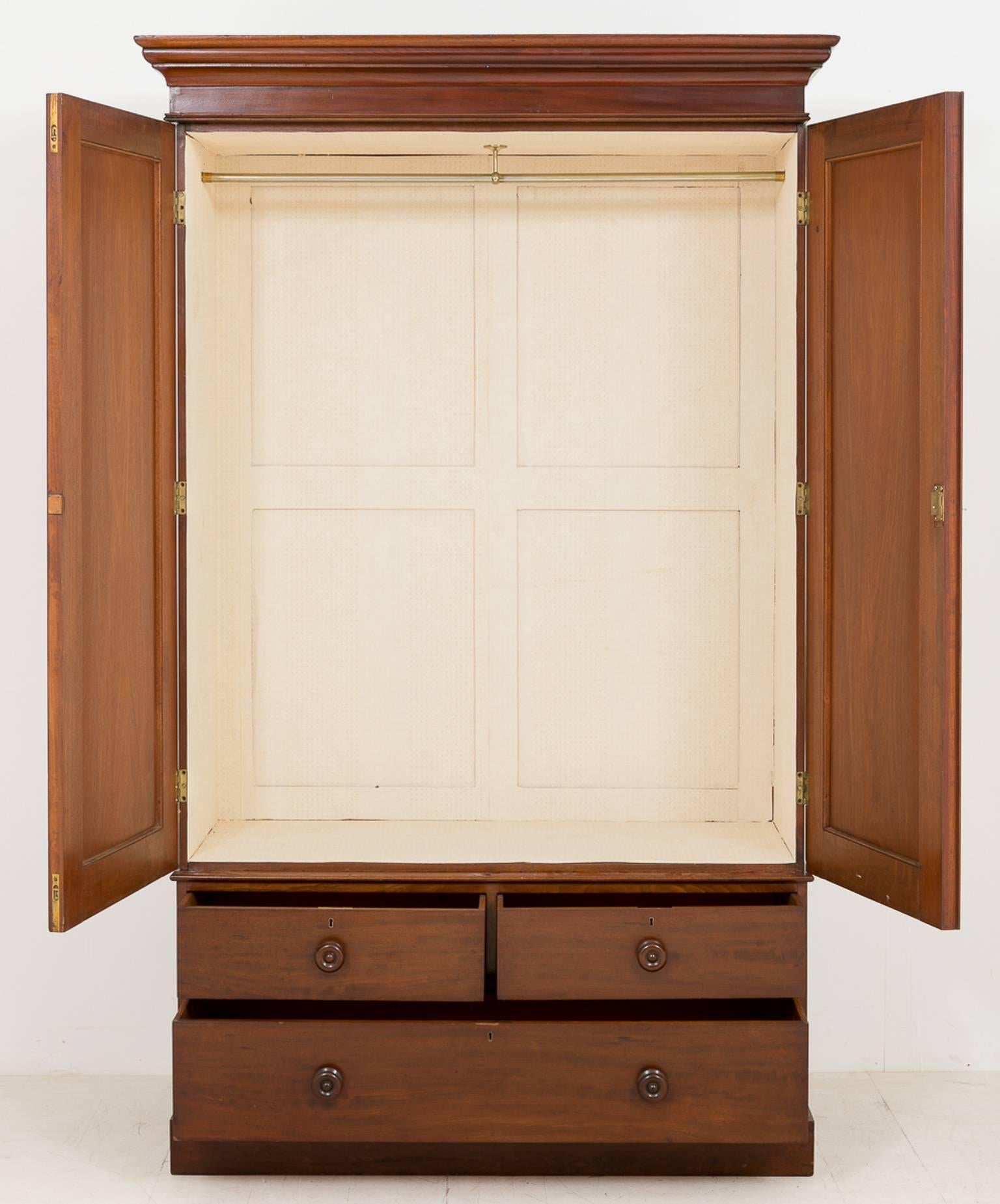 Mid-Victorian two-door mahogany wardrobe.
Standing on a plinth base with three deep drawers above.
Having two arched doors with good quality panels.
The interior is paper lined with hanging space.
This piece will break down into three