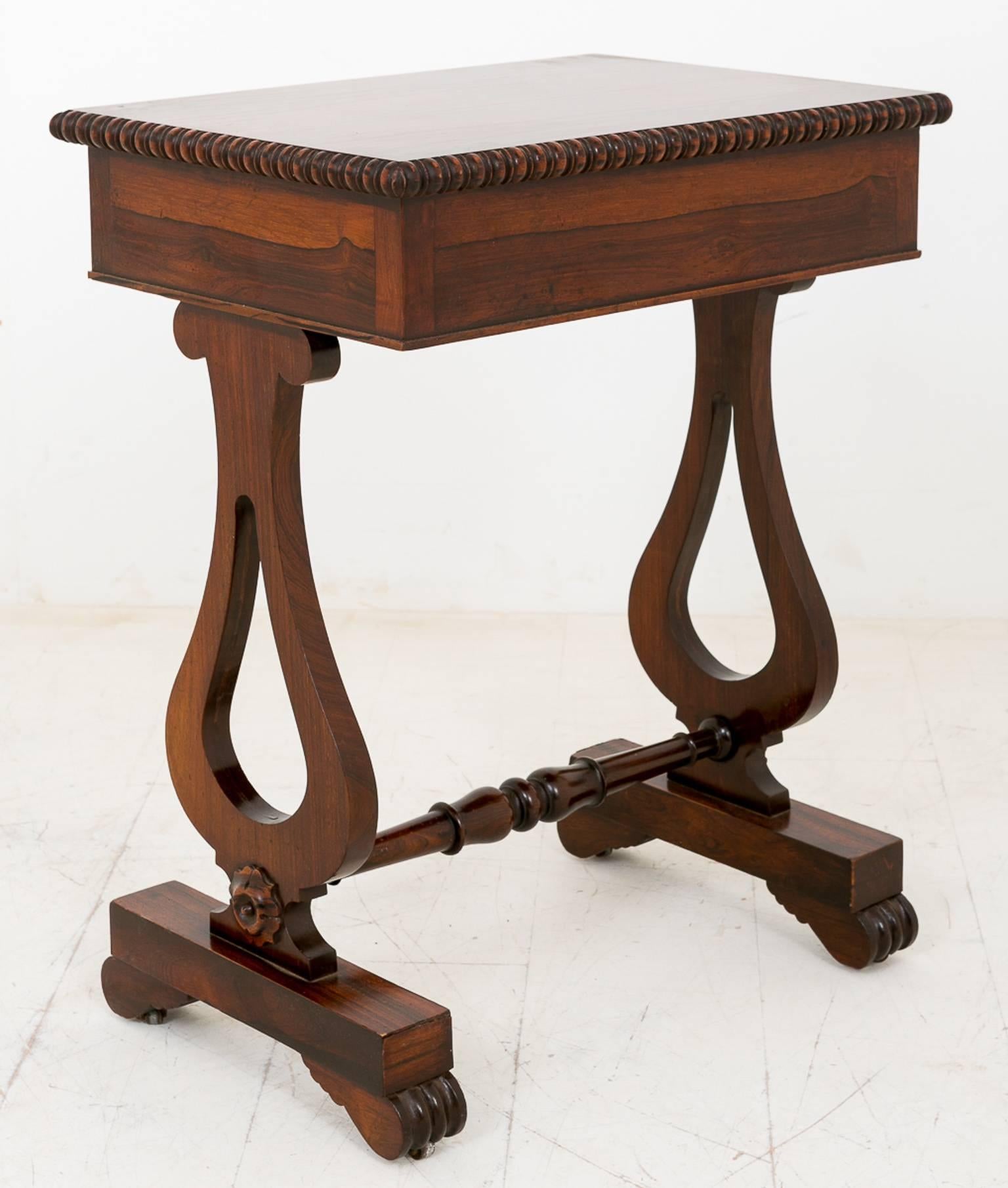 William IV Rio rosewood side table. Standing on turned feet, Lyre end supports with carved patrea together with a turned stretcher.
The mahogany lined drawer with original brass lock and knobs.
The highly figured top having a half turned