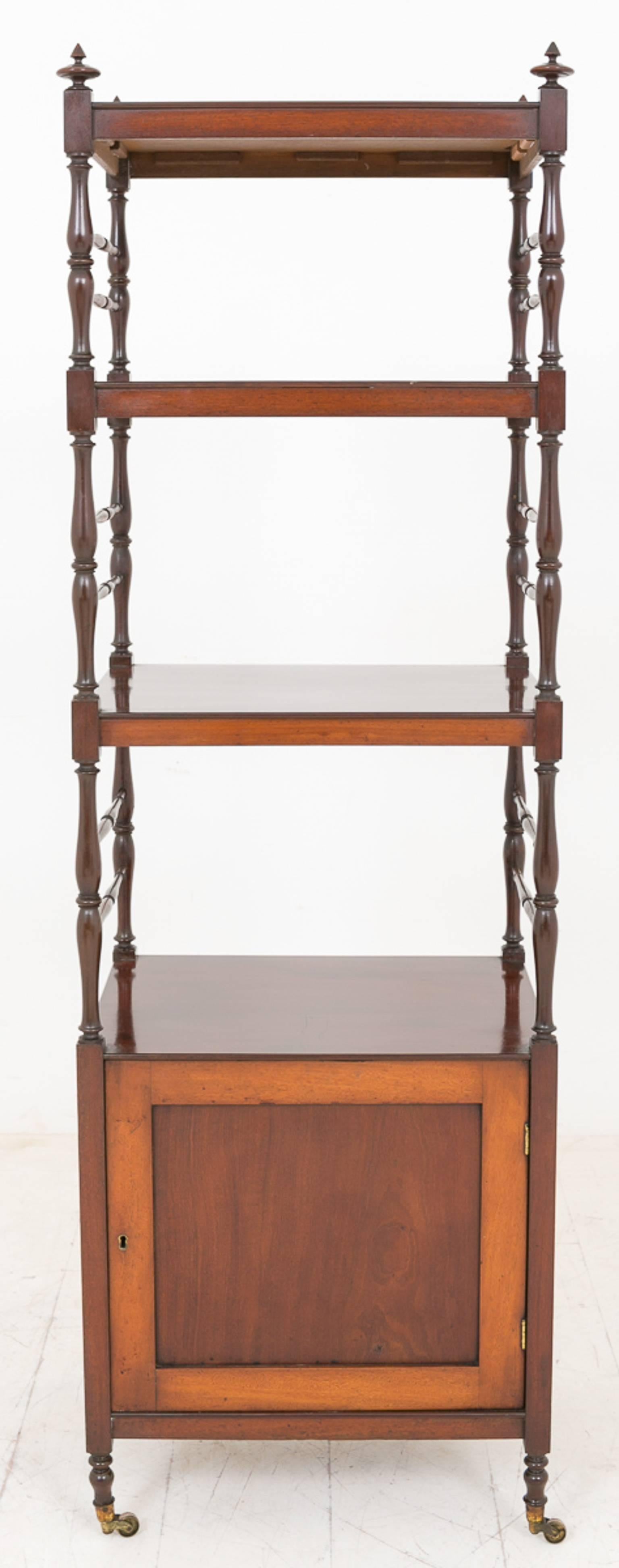 William IV mahogany whatnot.
Standing on brass castors and turned feet.
One cupboard with original brass lock.
The three upper shelves supported by turned columns.

Size:
Height 63