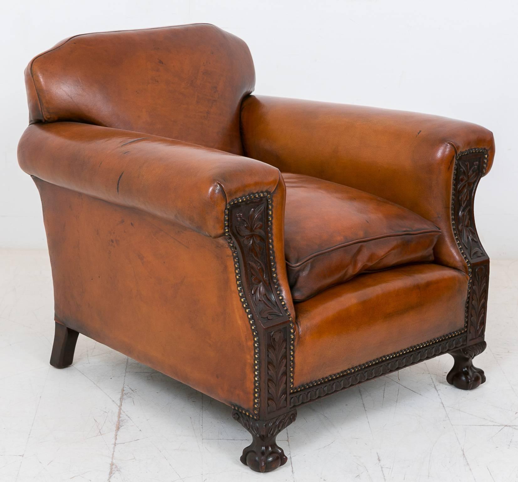 Pair of leather club chairs, standing on ball and claw feet with carved mouldings and carved leaf decoration.
Features hand nailed leather work.
These chairs are of a very good color and extremely comfortable.

Size:
Height 31 1/2 (80cm)
Width
