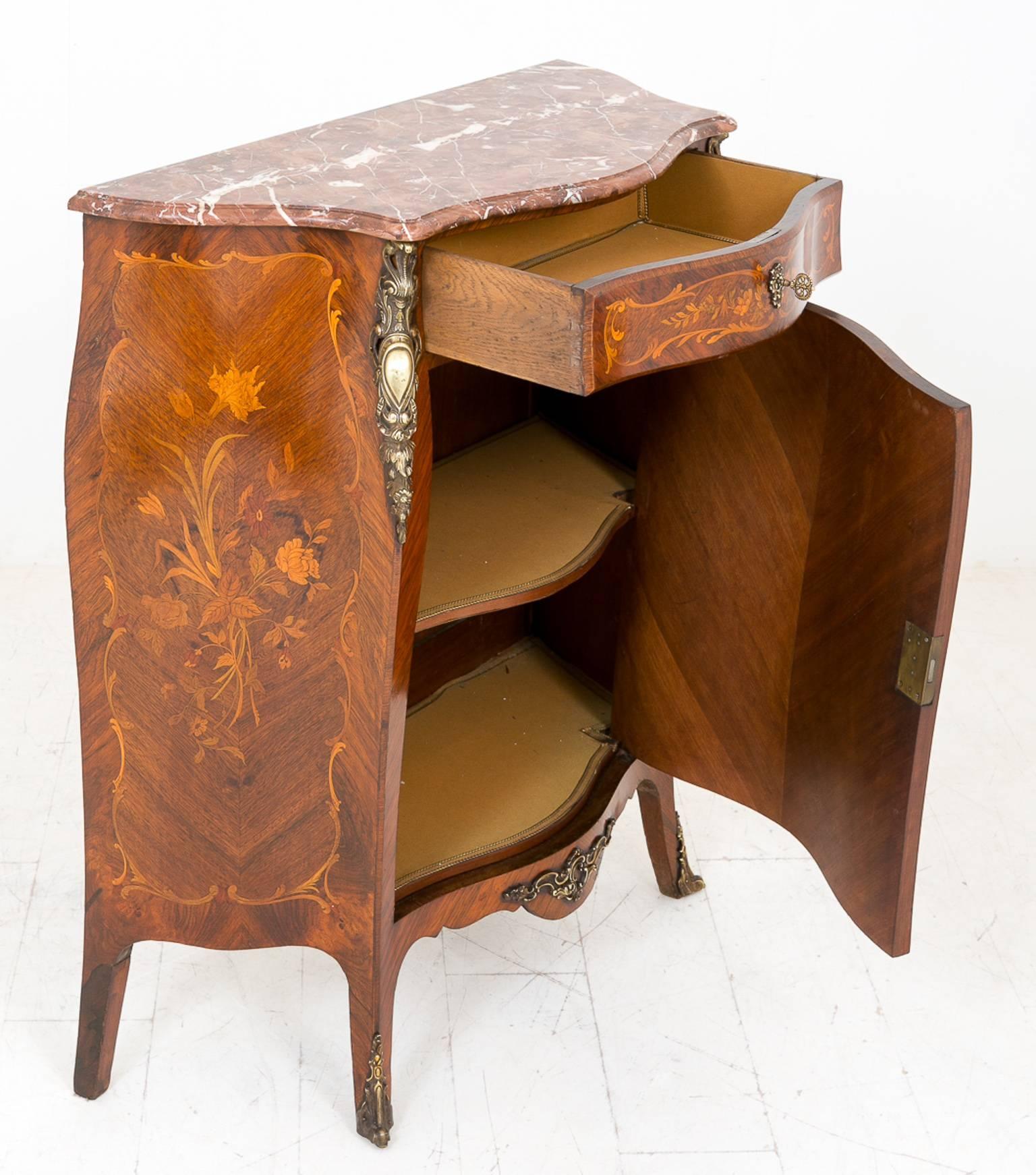 French marquetry side cabinet.
Standing on swept legs with cast brass toes.
The central quartered door with rosewood cross bandings and a central marquetry cartouche.
The bombe shaped sides with a similar format of marquetry and