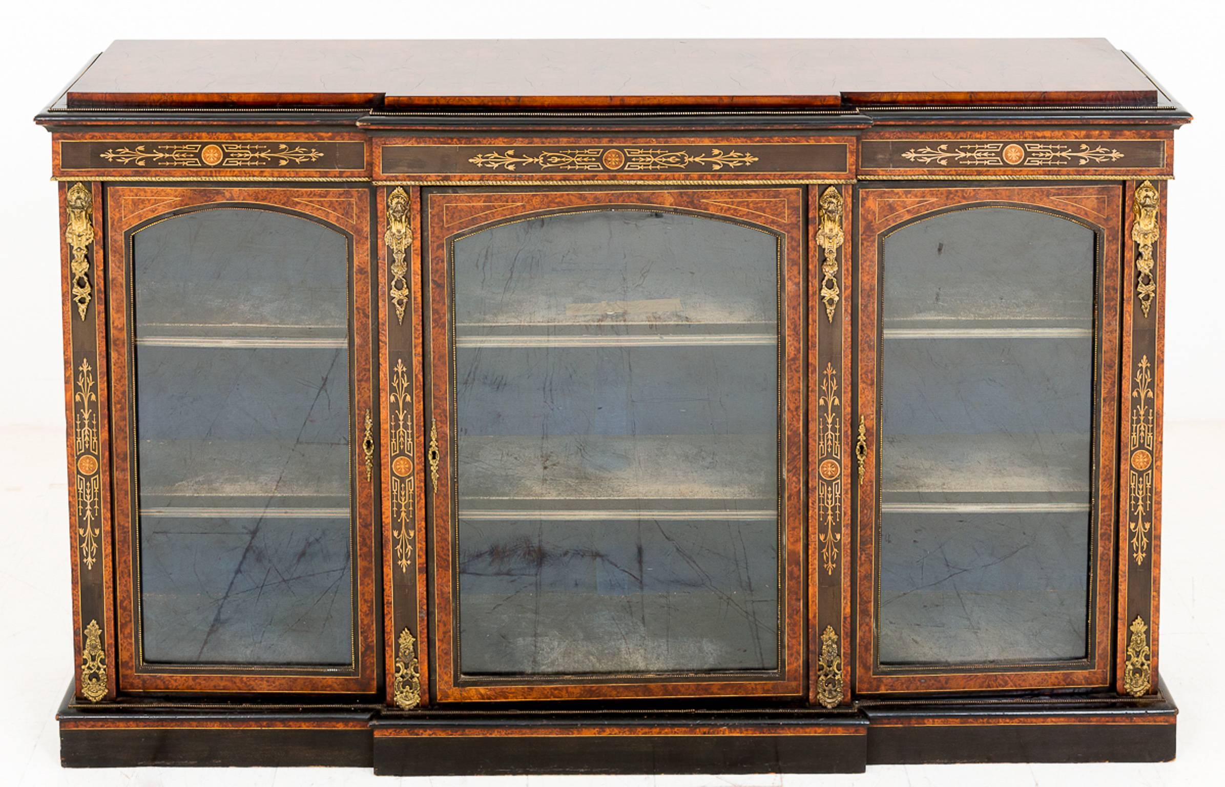 A beautiful three-door breakfront cabinet.
Having stunning burr walnut veneers and gilt metal mounts and mouldings.
The ebony panels featuring marquetry inlays and the interior shelves with the original velor.

Size:
Height 37