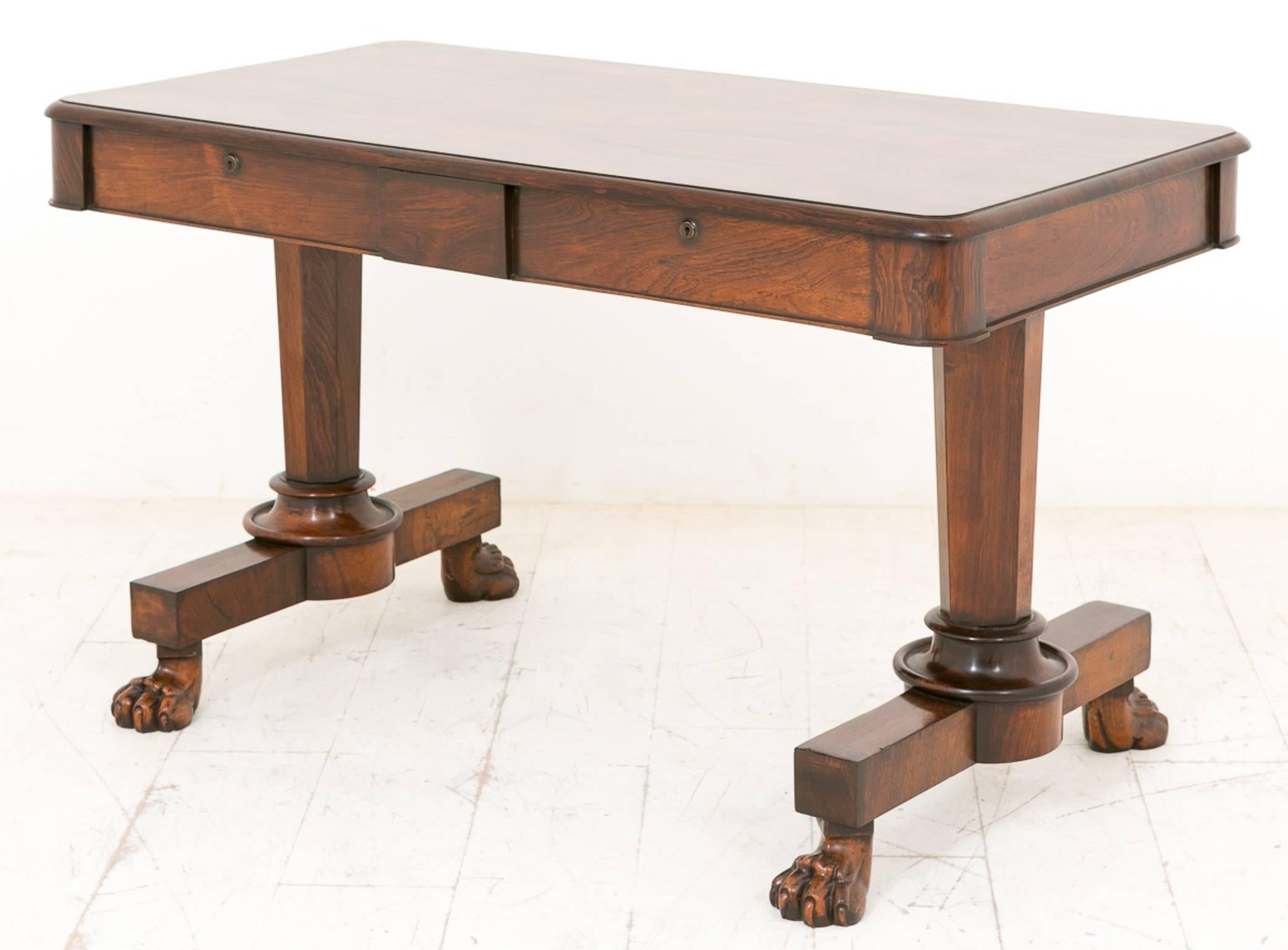 William IV rosewood library table standing on carved lions feet with turned and faceted columns.
This table features two mahogany lined drawers with original locks and ring pull handles.
The top of the table having highly figured Rio rosewood